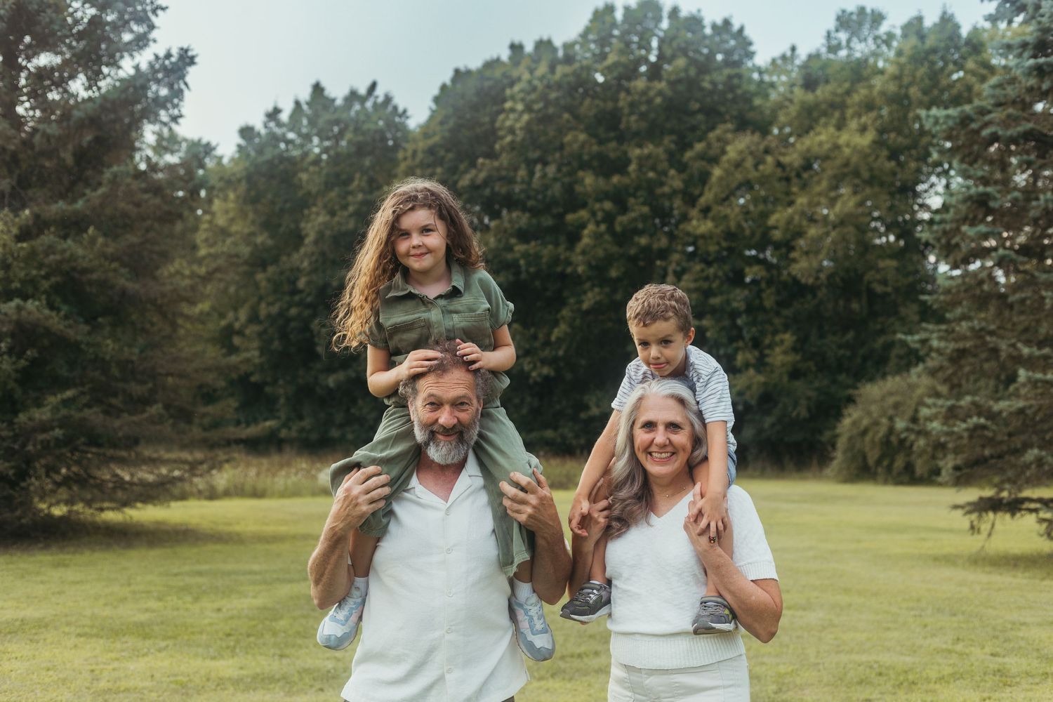 Candid family portrait from a Lapeer, Michigan photo session with parents, children, and grandparents outdoors
