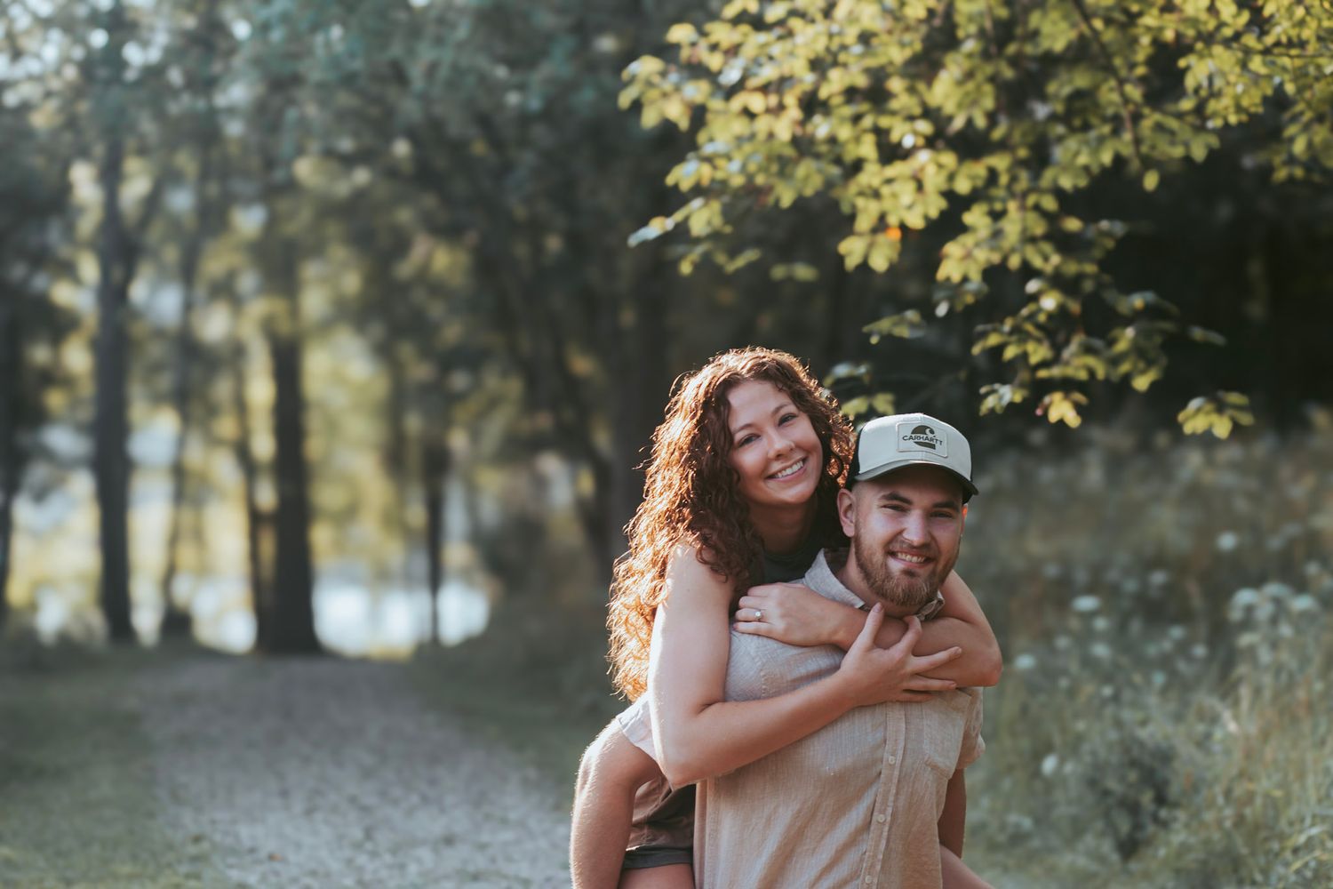 Outdoor couples portrait during an Oakland County family photo session featuring a couple standing together on a wooded trail