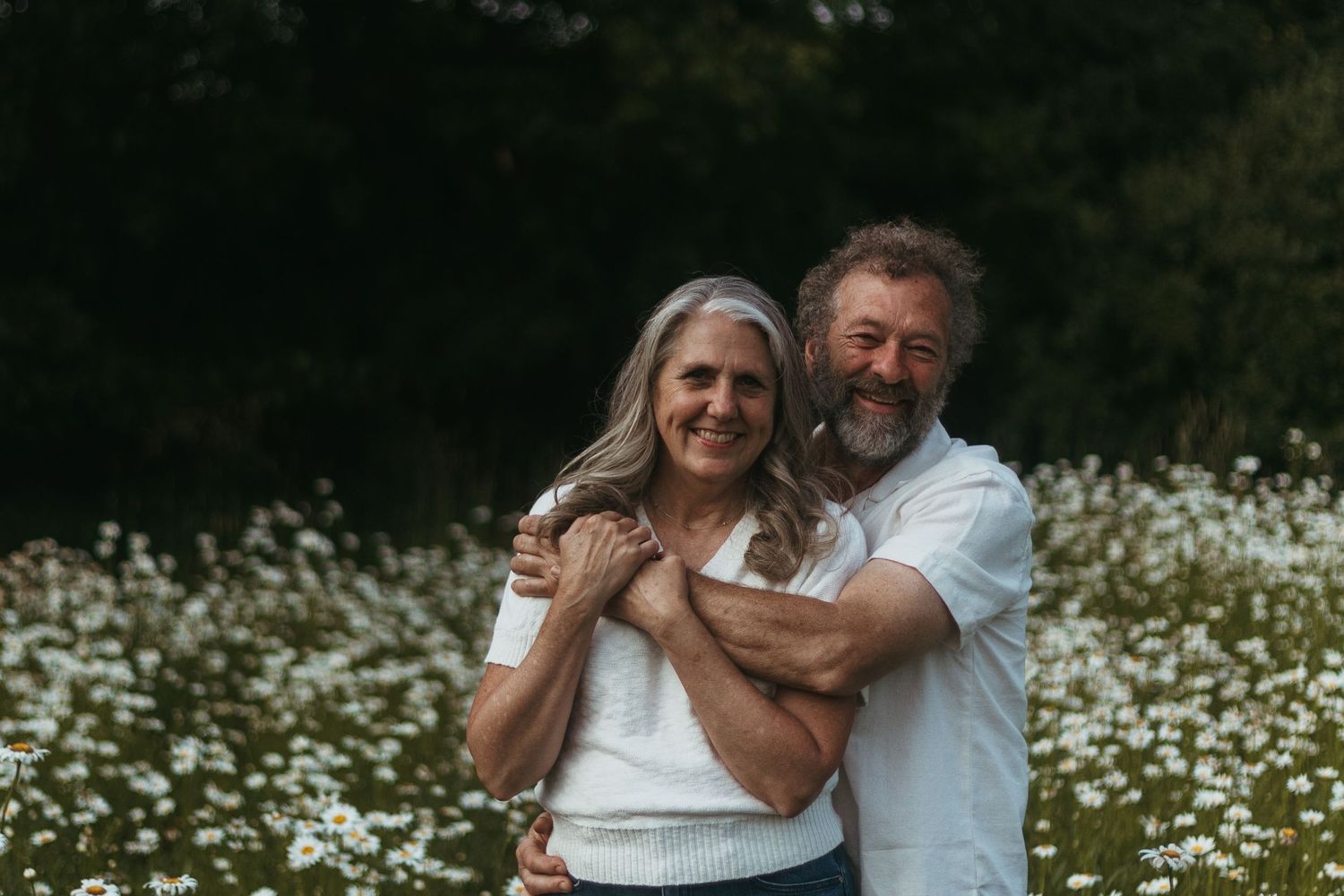 Couple embracing in a wildflower field during a family session with a Southeast Michigan photographer near Detroit.