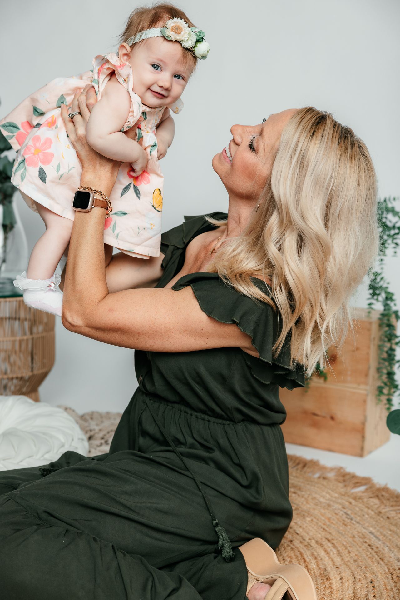 Mommy N me session. Mom and baby share playful moments together while sitting on a textured surface boho style with eucalyptus