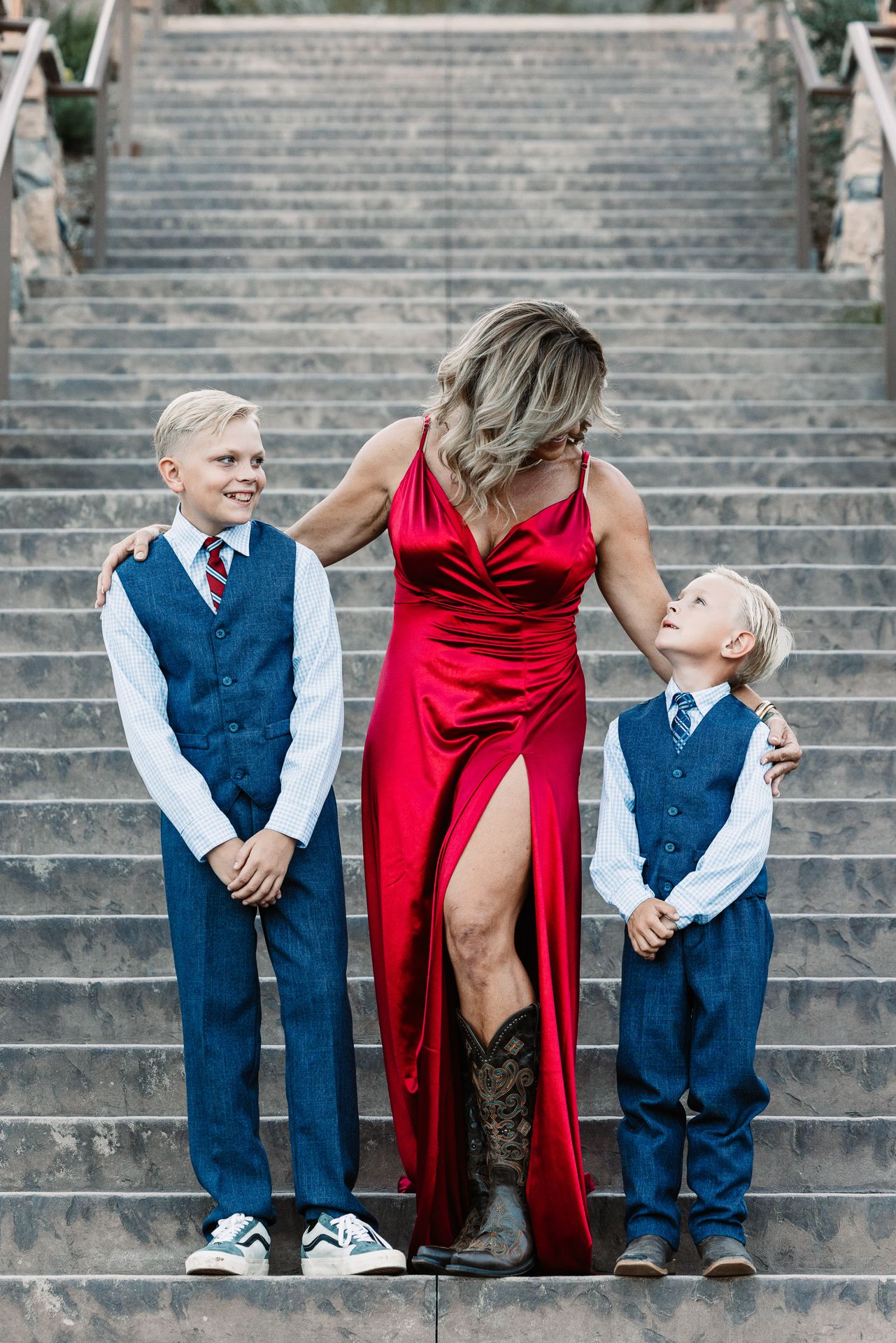 Woman in red gown with two blonde boys in blue suits posing on stone steps.  In Bonsall, near Fallbrook