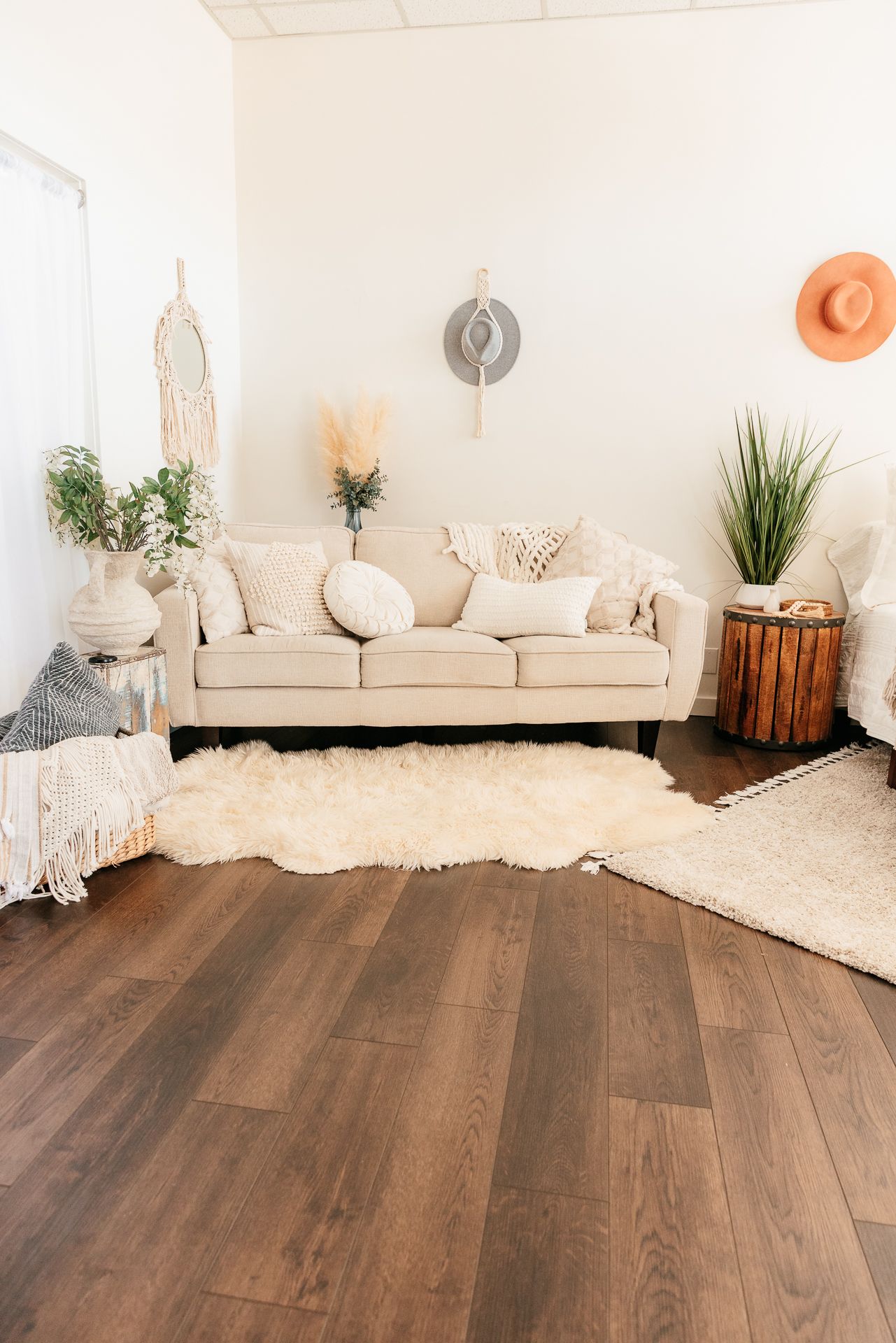 Bohemian living space with cream sofa, shag rug, macrame mirror, pampas grass, and dark wood floors. in the Bonsall Studio near Fallbrook, V