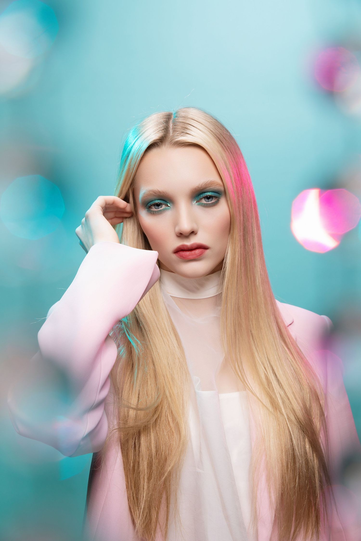 Artistic portrait with soft turquoise background and pink accents long blonde hair and dreamy makeup styling shot through diamonds w/ gells