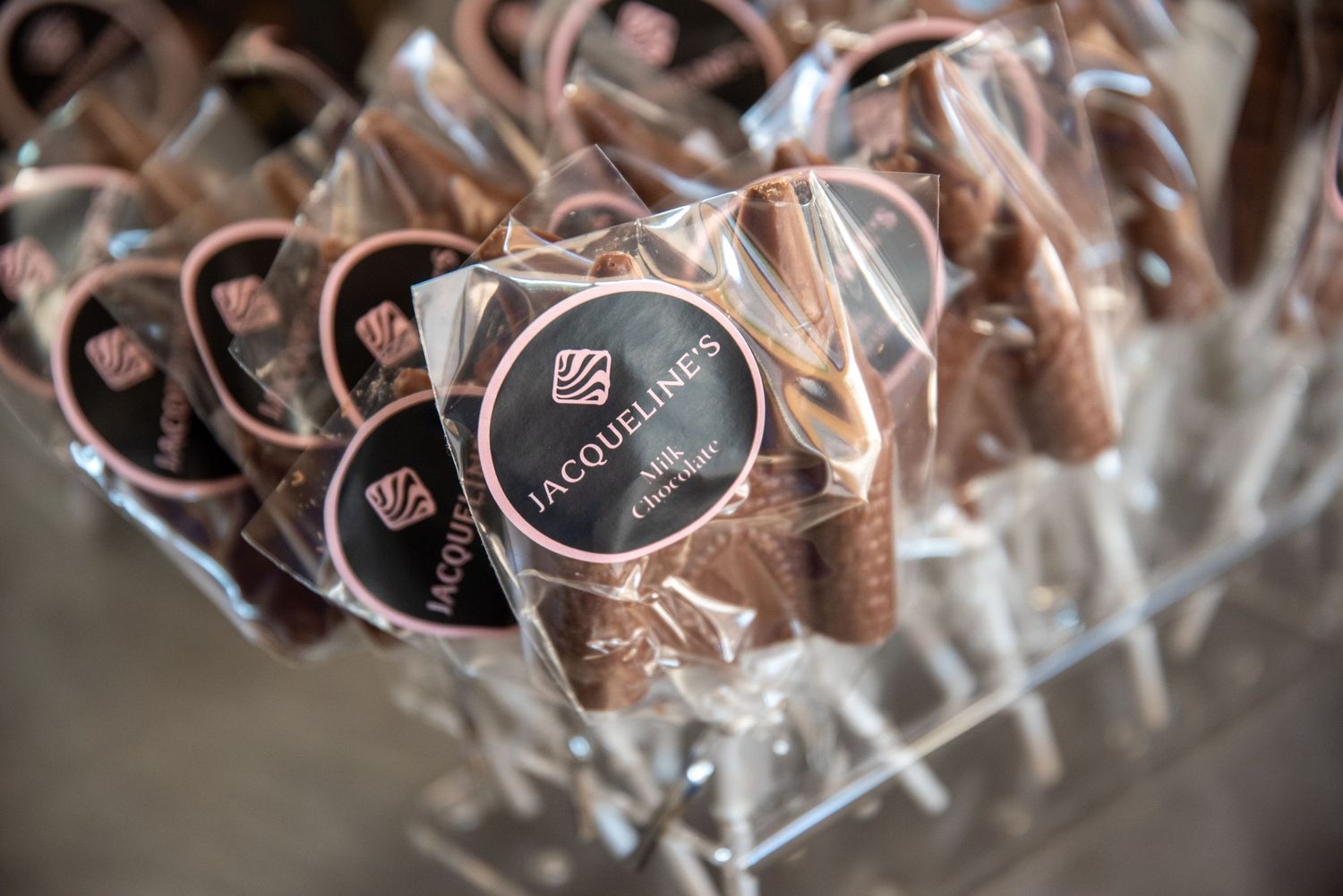 Wrapped chocolate truffles with Jacqueline's branded logos displayed in clear packaging.
