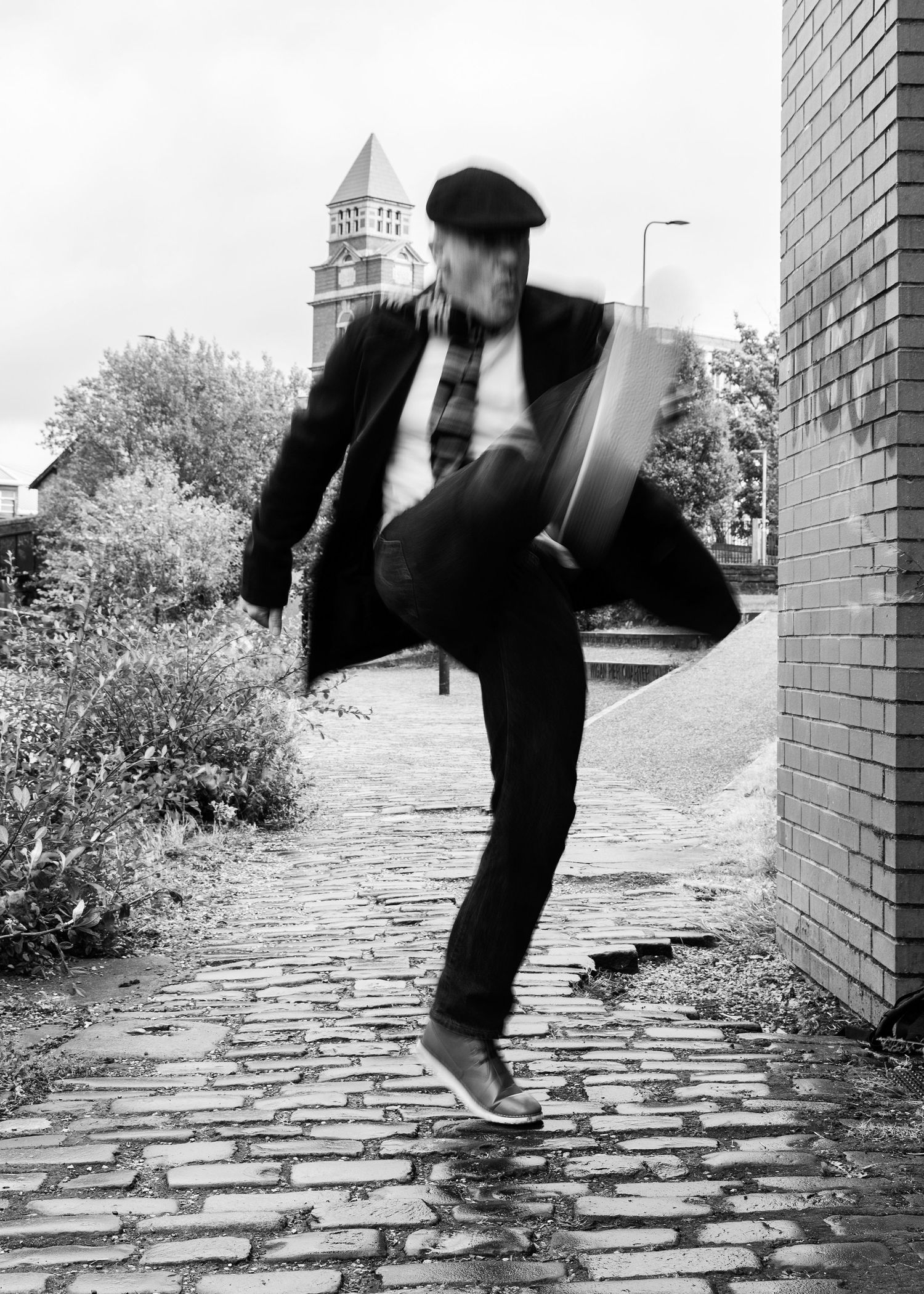 Black and white photo sequence shows a person's legs walking across cobblestone pavement in vintage style.