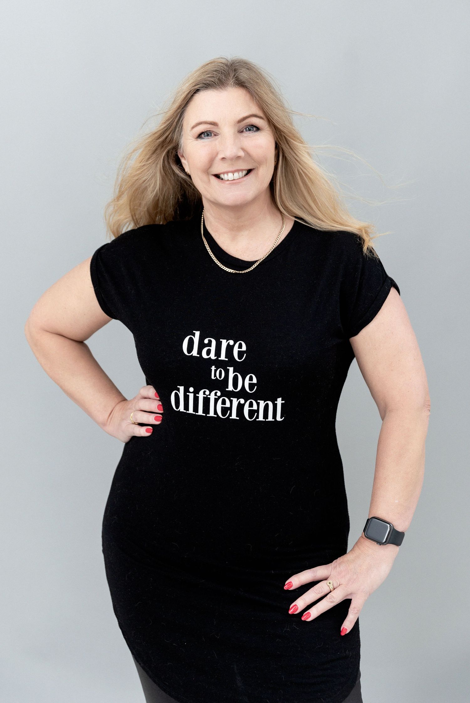 A black t-shirt with white text reading 'dare to be different' styled in a casual fashion.