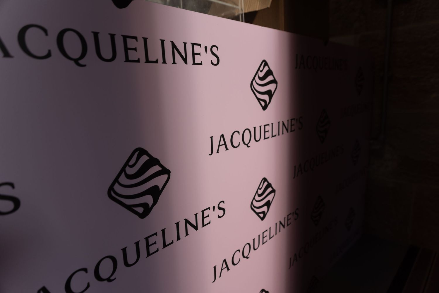 Jacqueline's branded logo and text display against dark background.