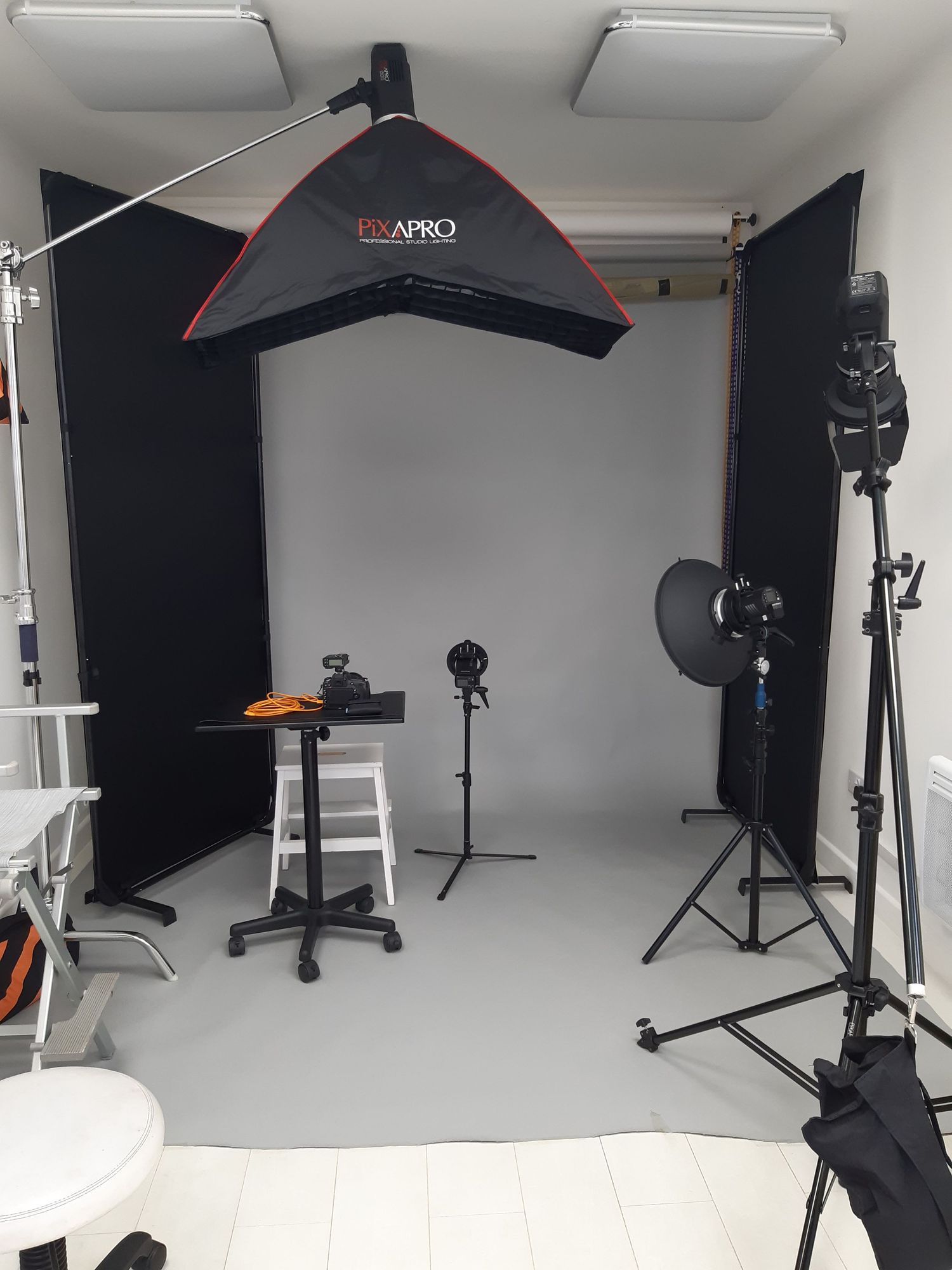 Professional photography studio setup with lighting equipment and black backdrop.