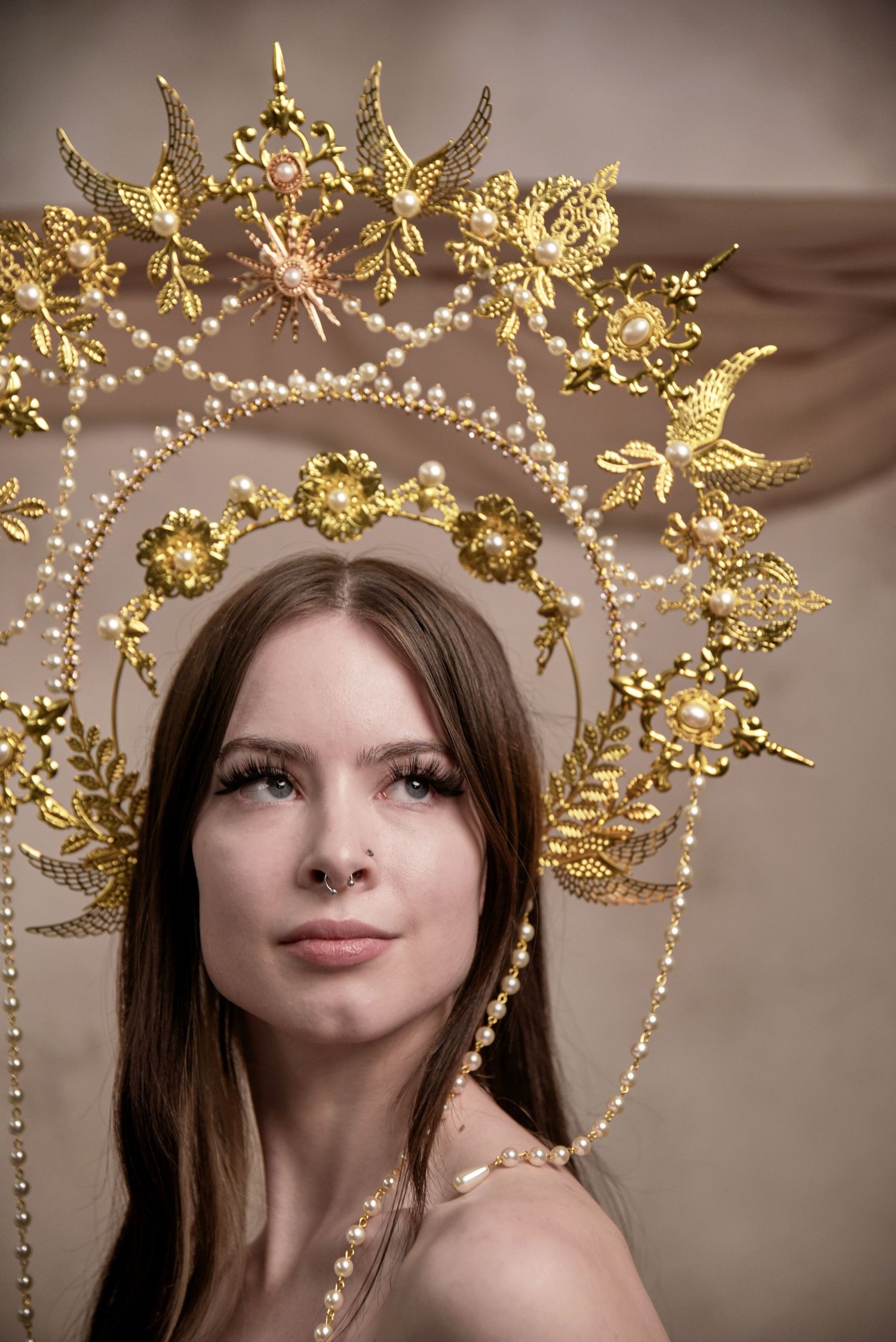 Portrait with elaborate golden halo crown adorned with pearls and decorative birds.