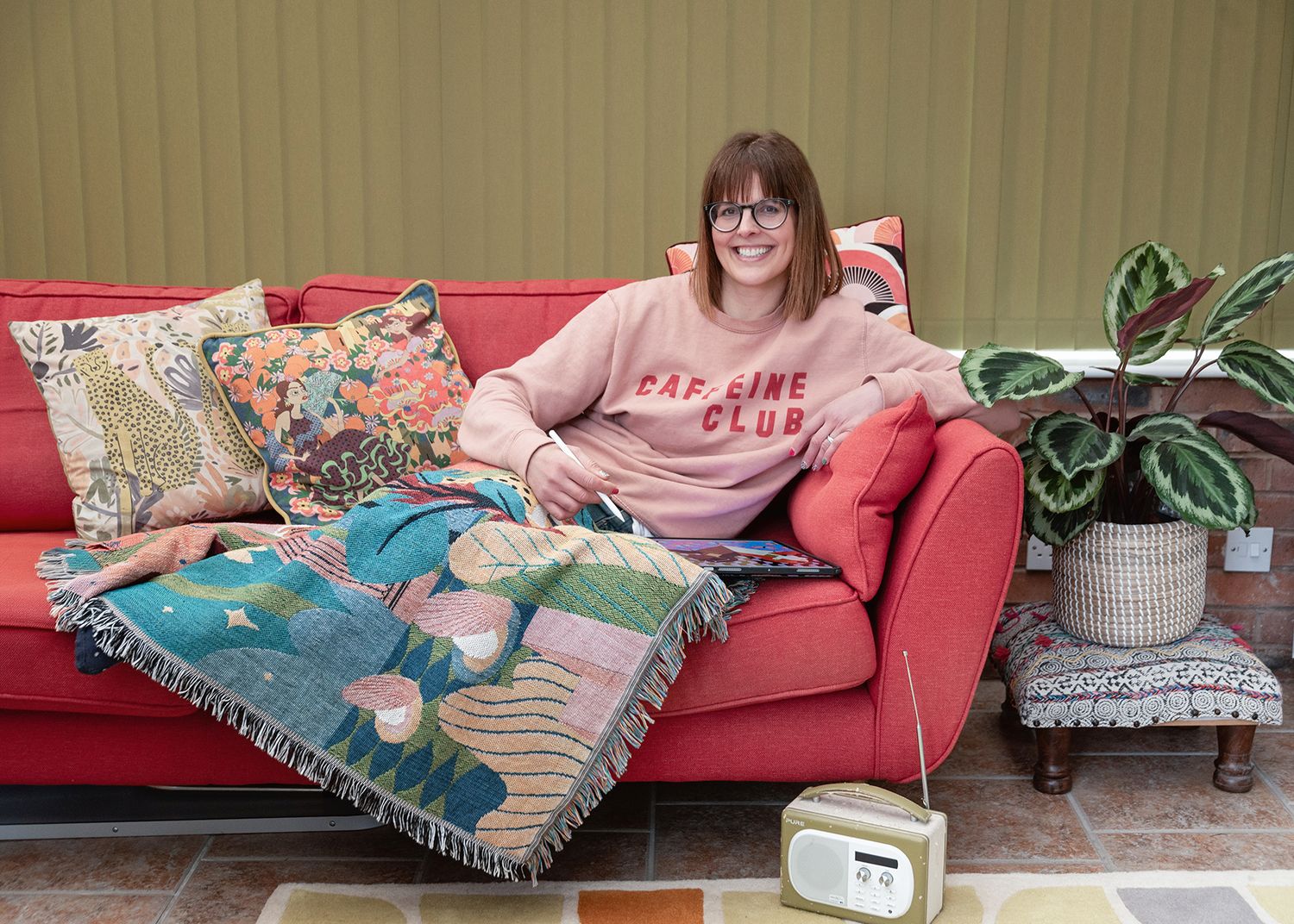 A sequence of five photos showing someone lounging and relaxing on a pink couch with throw blankets and pillows.