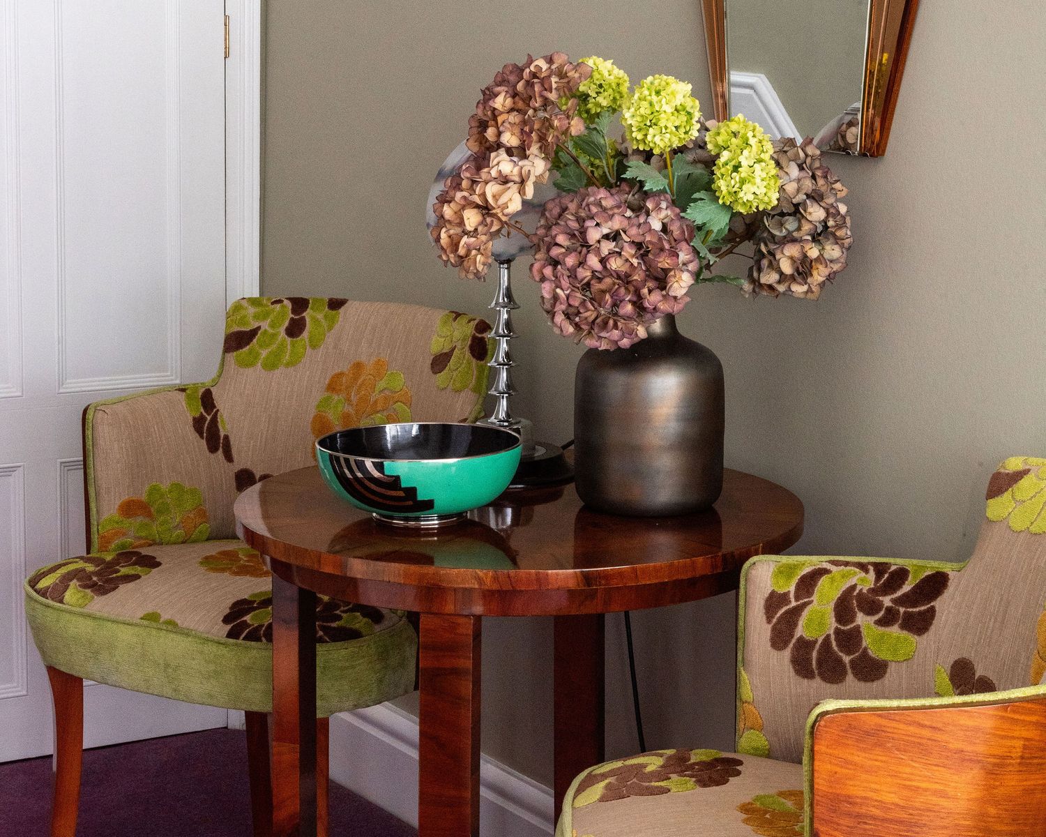 A series of wooden side tables with decorative vases and floral arrangements displayed in a row.