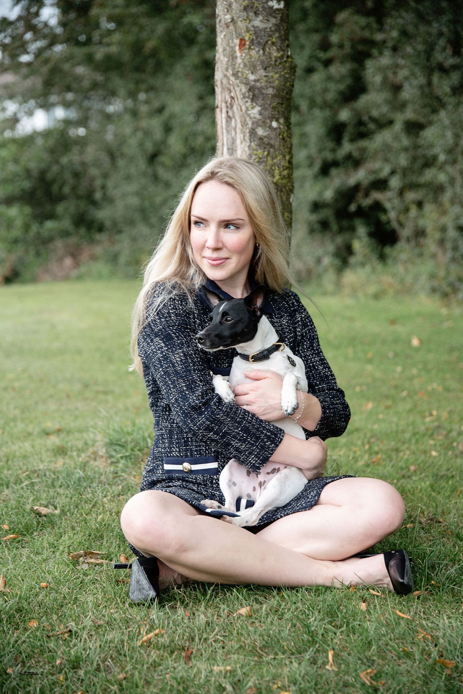 Casual outdoor portrait with a black and white cat in a garden setting.