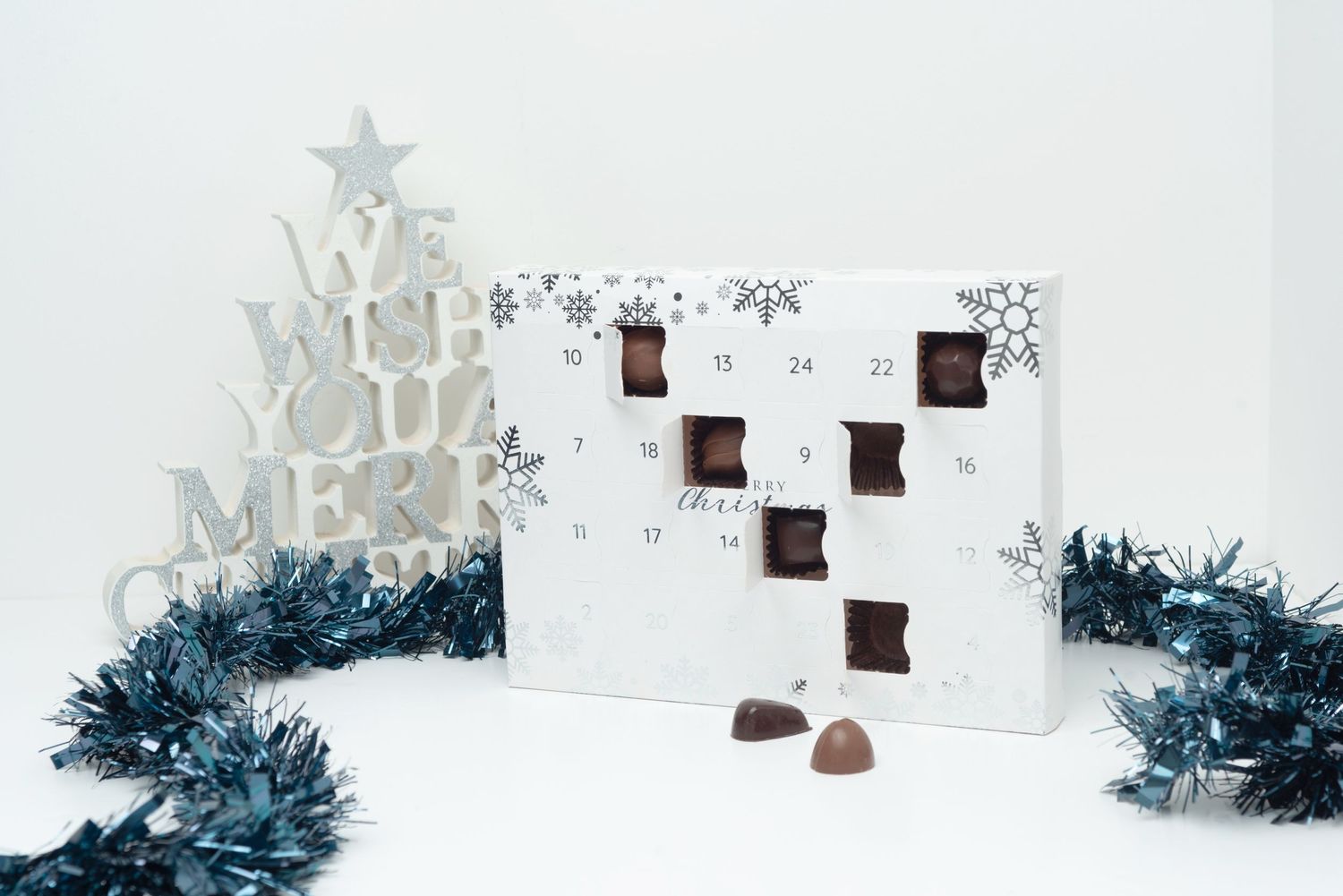 Christmas advent calendar with decorative tree and blue tinsel garland.