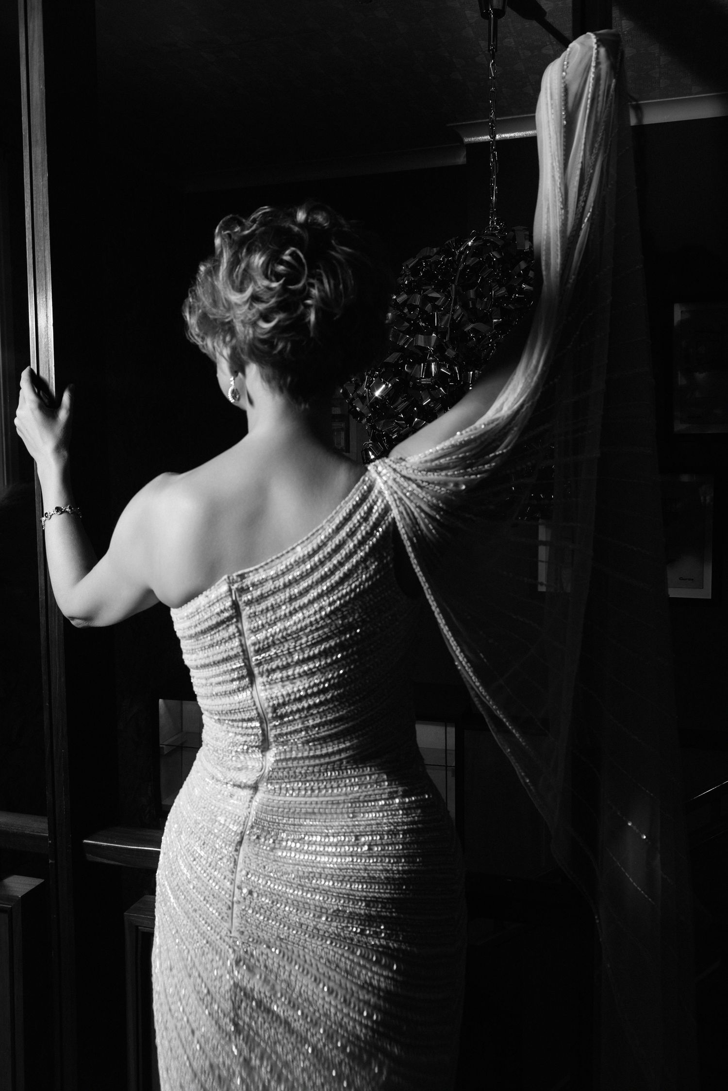 Back view of beaded gown with dramatic flowing cape in black and white.