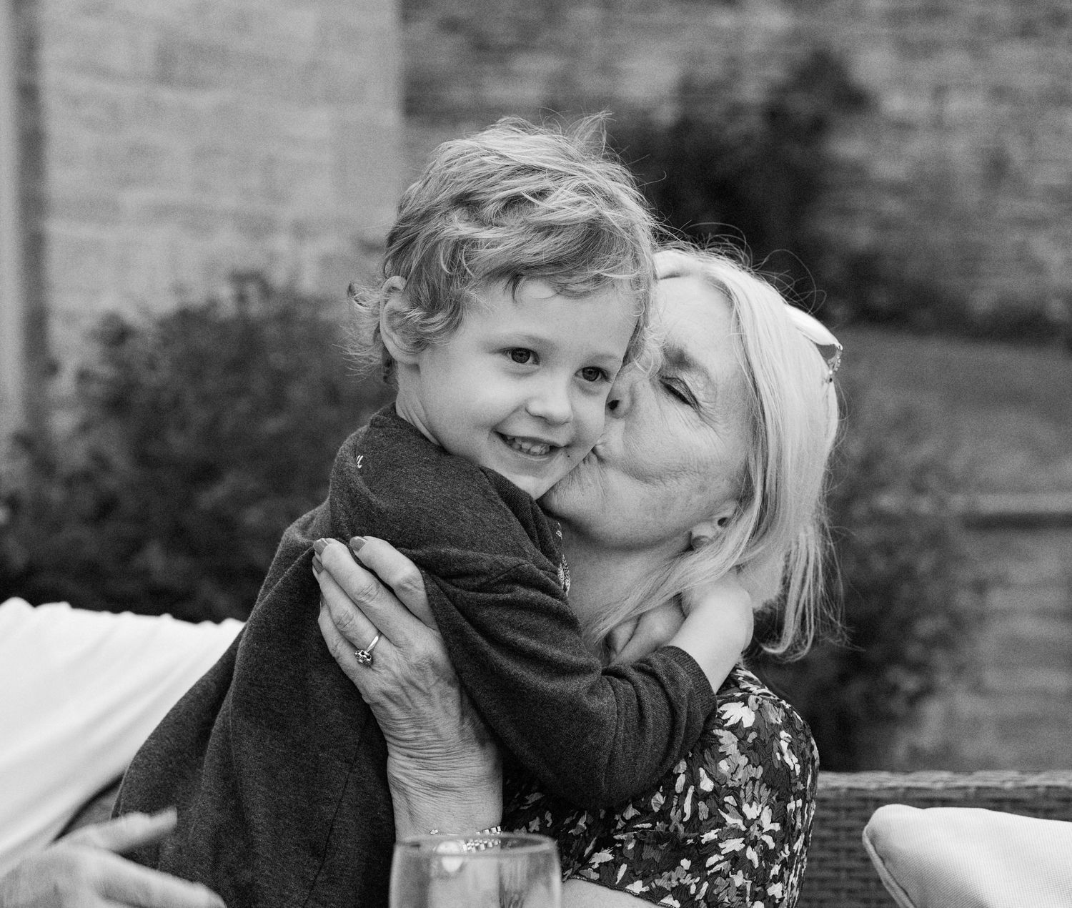 A series of black and white photos showing tender moments between parent and child in candid outdoor settings.