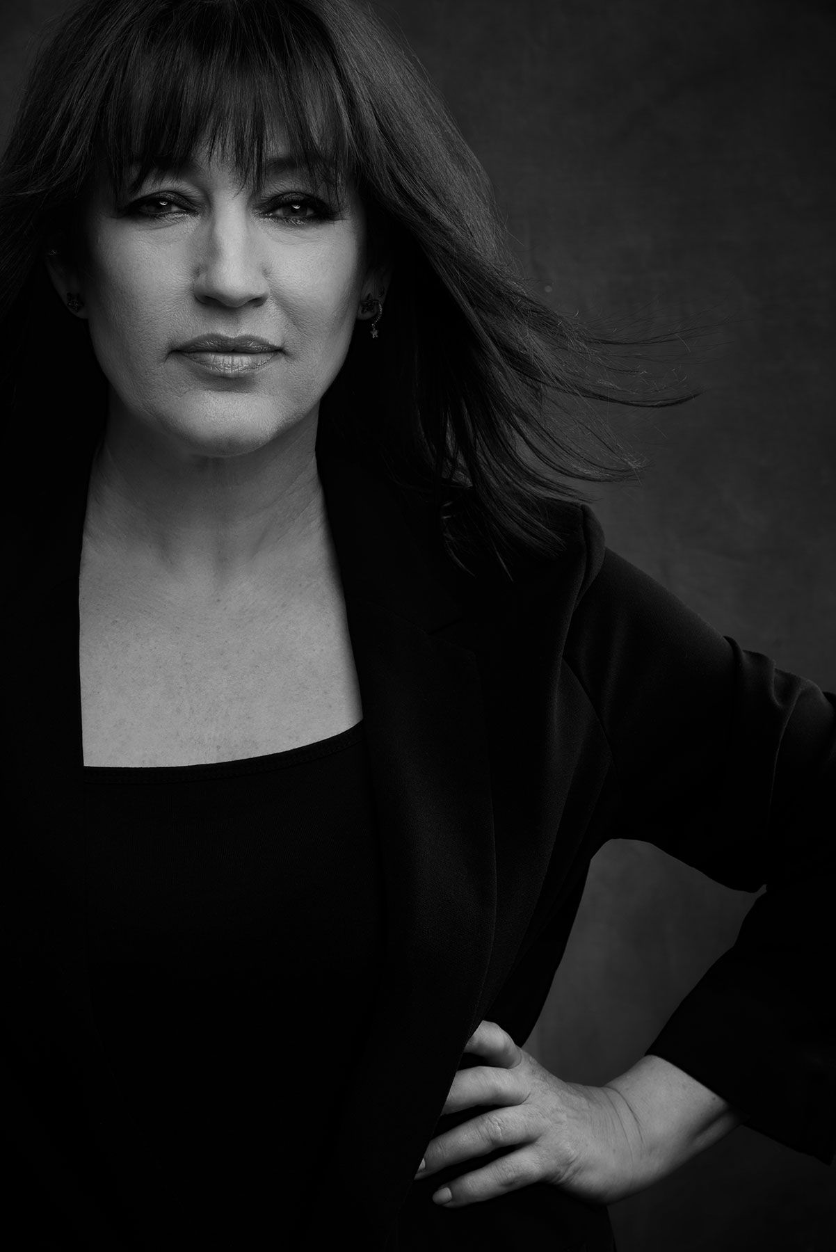 Black and white portrait with dramatic side lighting against dark background.
