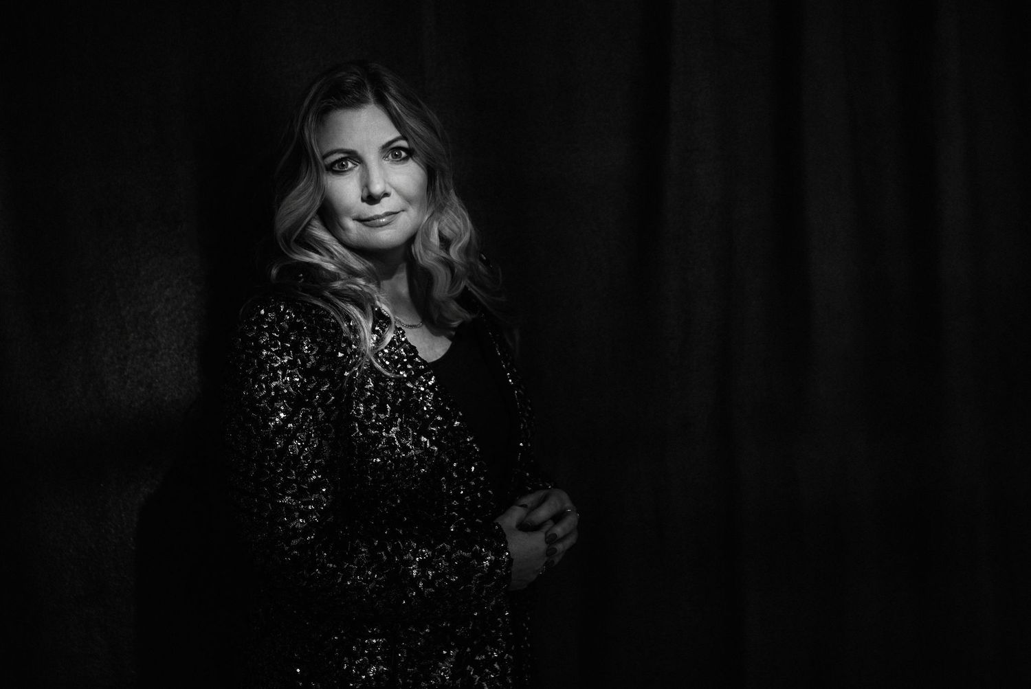 A dramatic black and white portrait featuring a sparkly evening jacket and flowing hair.