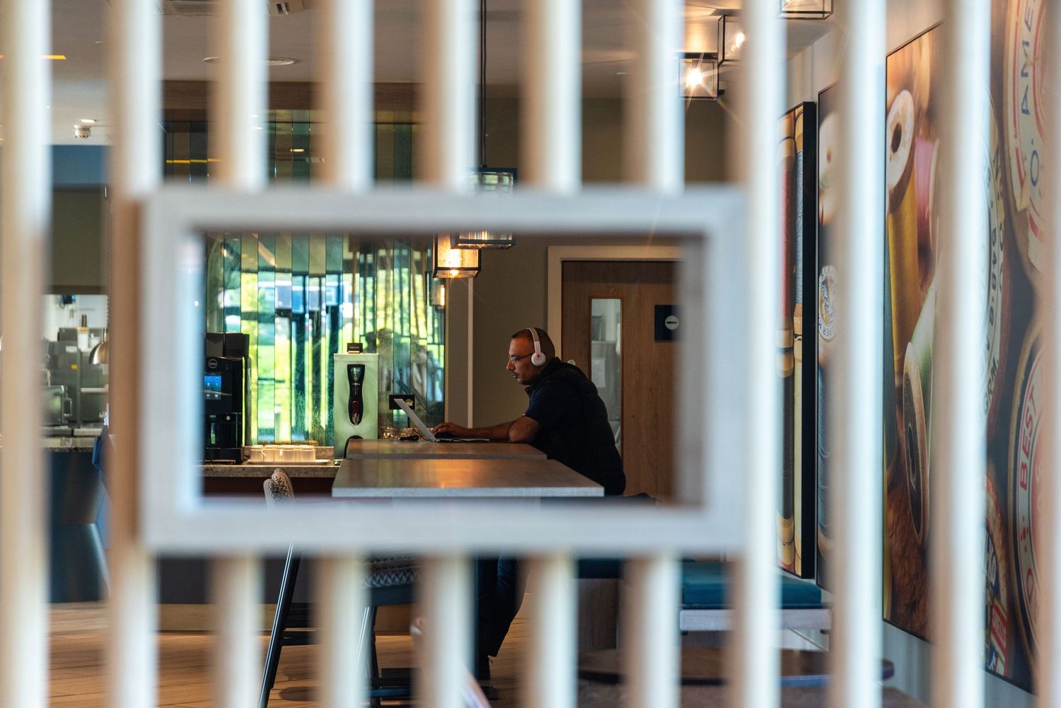 View through decorative divider into hotel fitness center with mirrors and equipment.