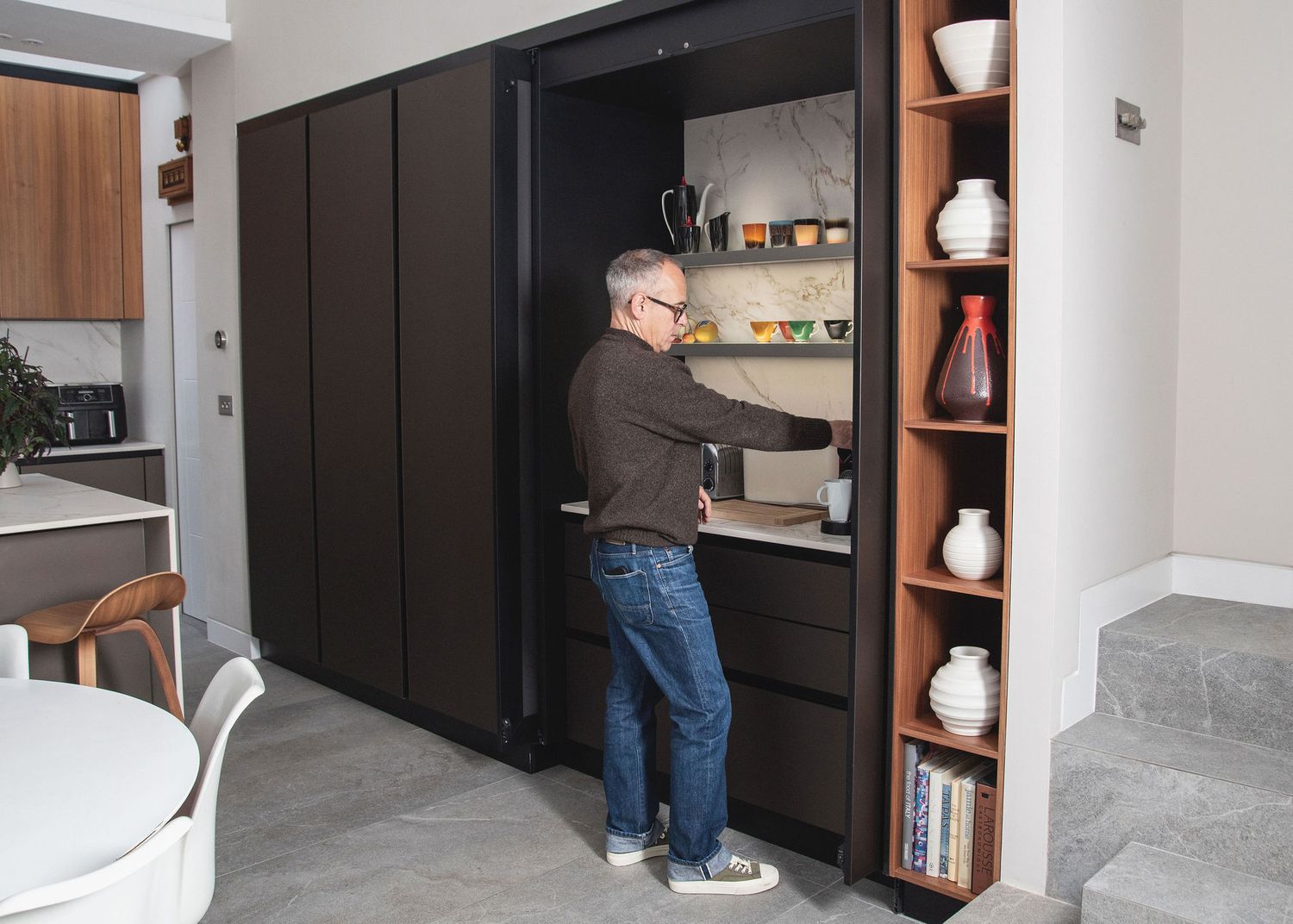A series of progress photos showing installation of dark cabinet doors in a modern kitchen renovation.