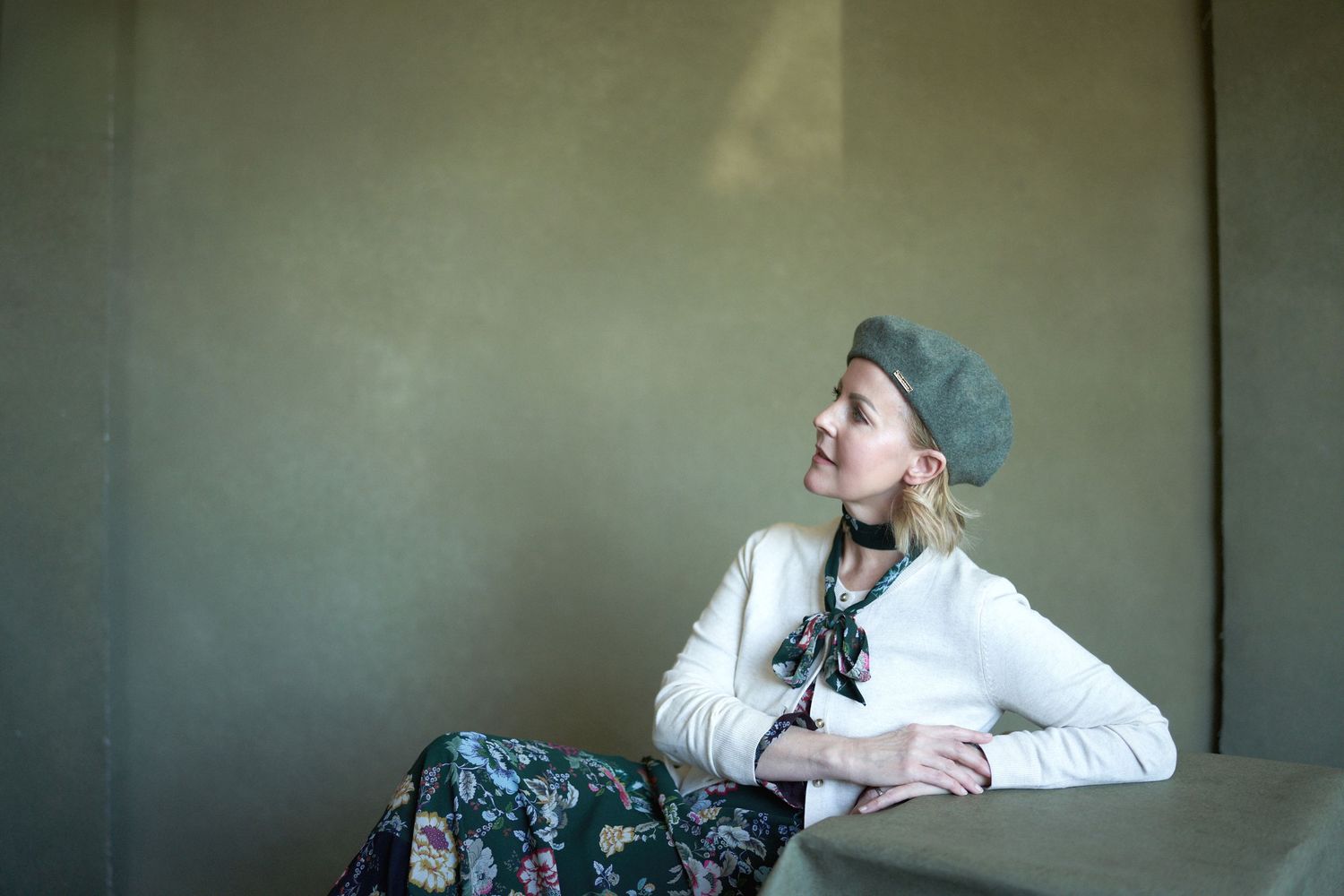 Casual indoor portraits showing relaxed poses against a neutral wall.