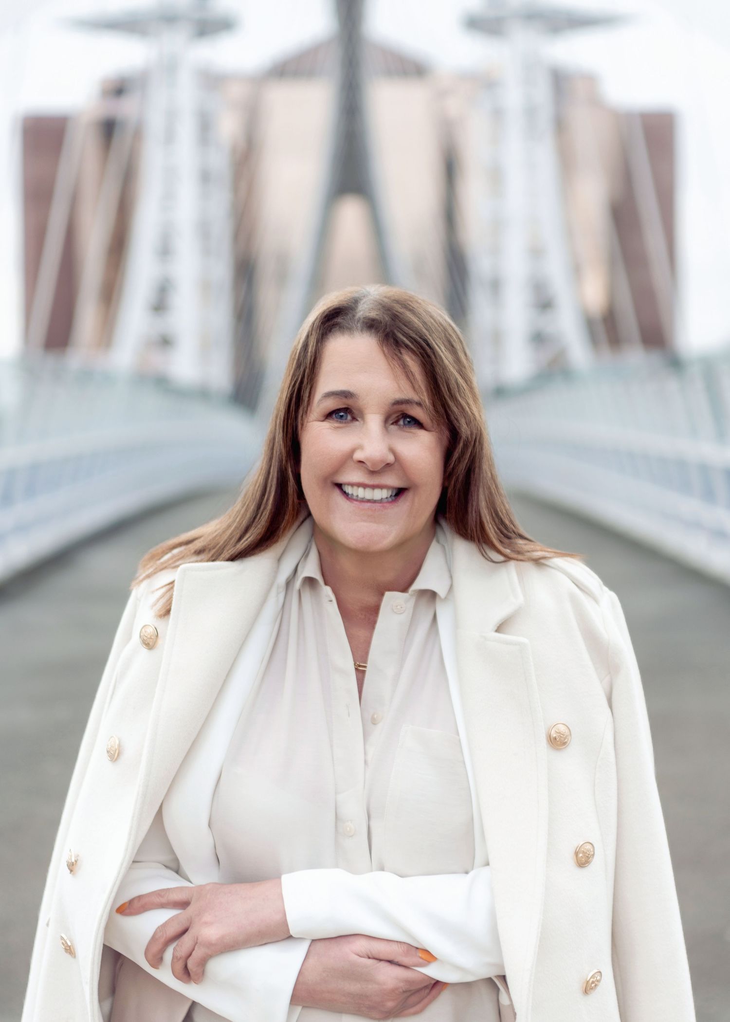 Professional headshot series showing someone in a white blazer with gold buttons against a light background.