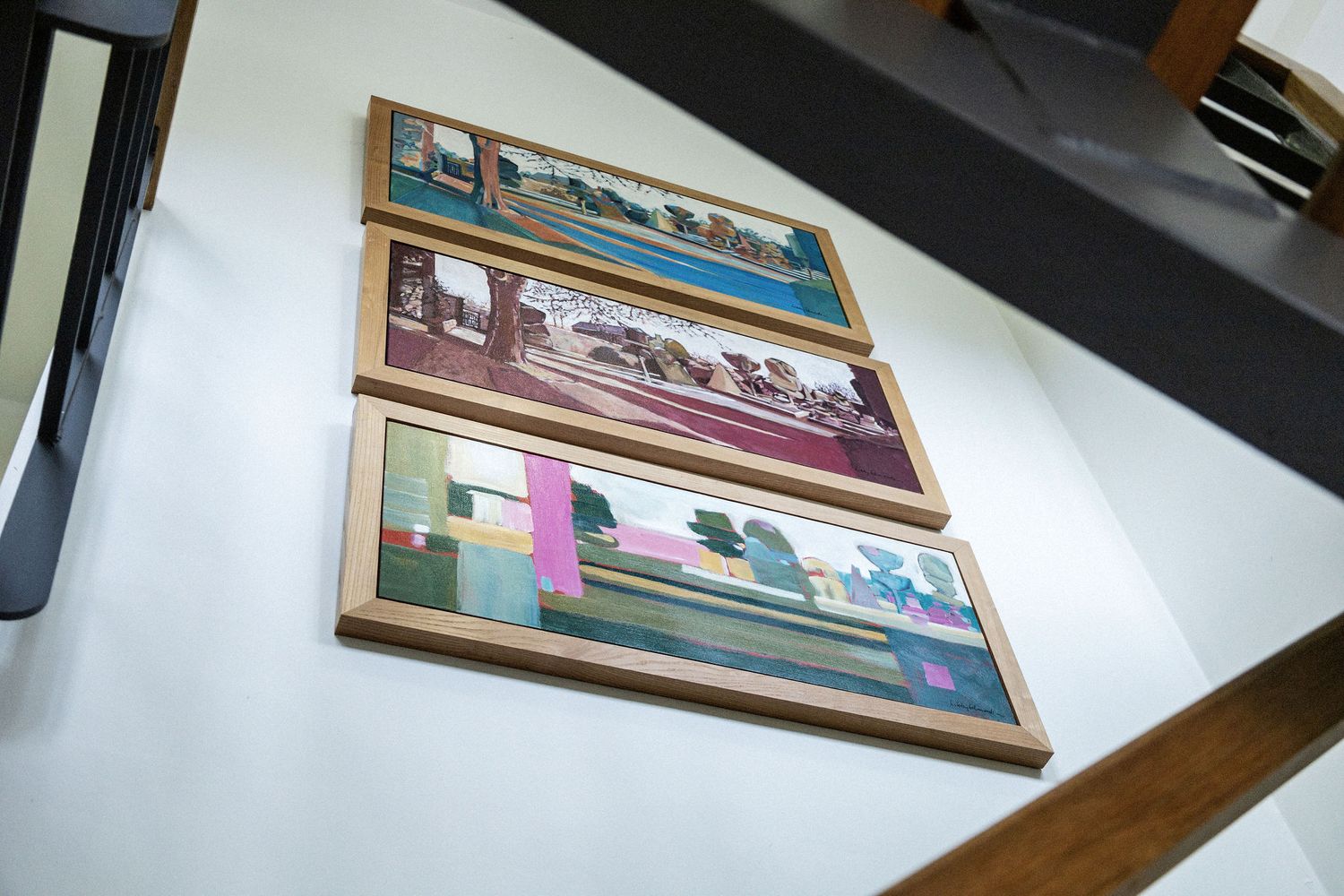 Three framed landscape artwork pieces displayed on a white wall.