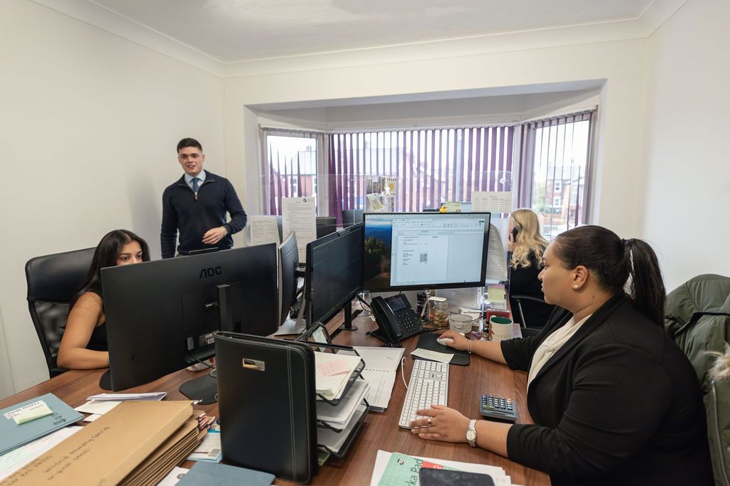 Students working at computer workstations in a modern training classroom with monitors and desks.