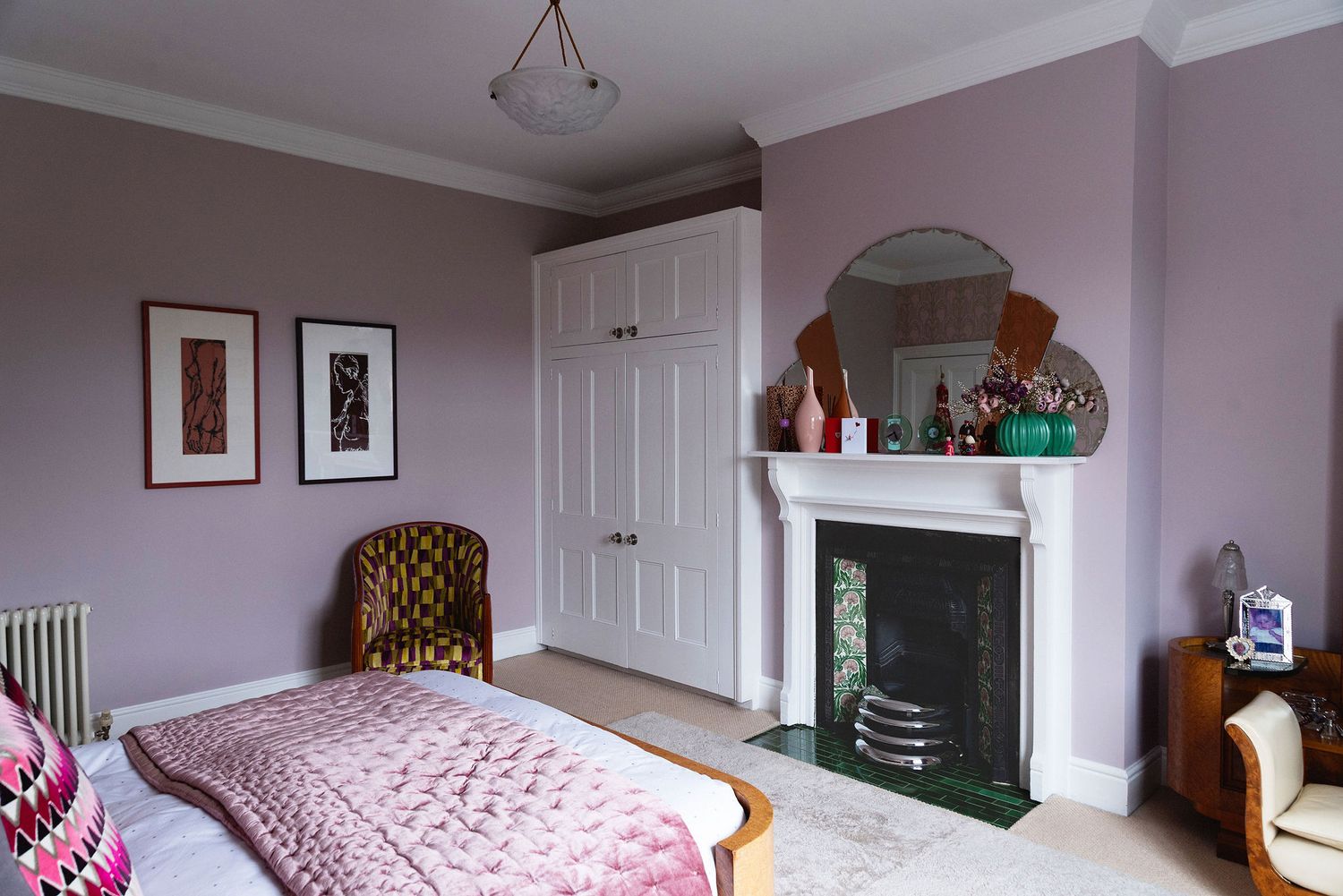 A panoramic view of a modern bedroom interior with white walls, wooden furniture, and pink accents throughout.