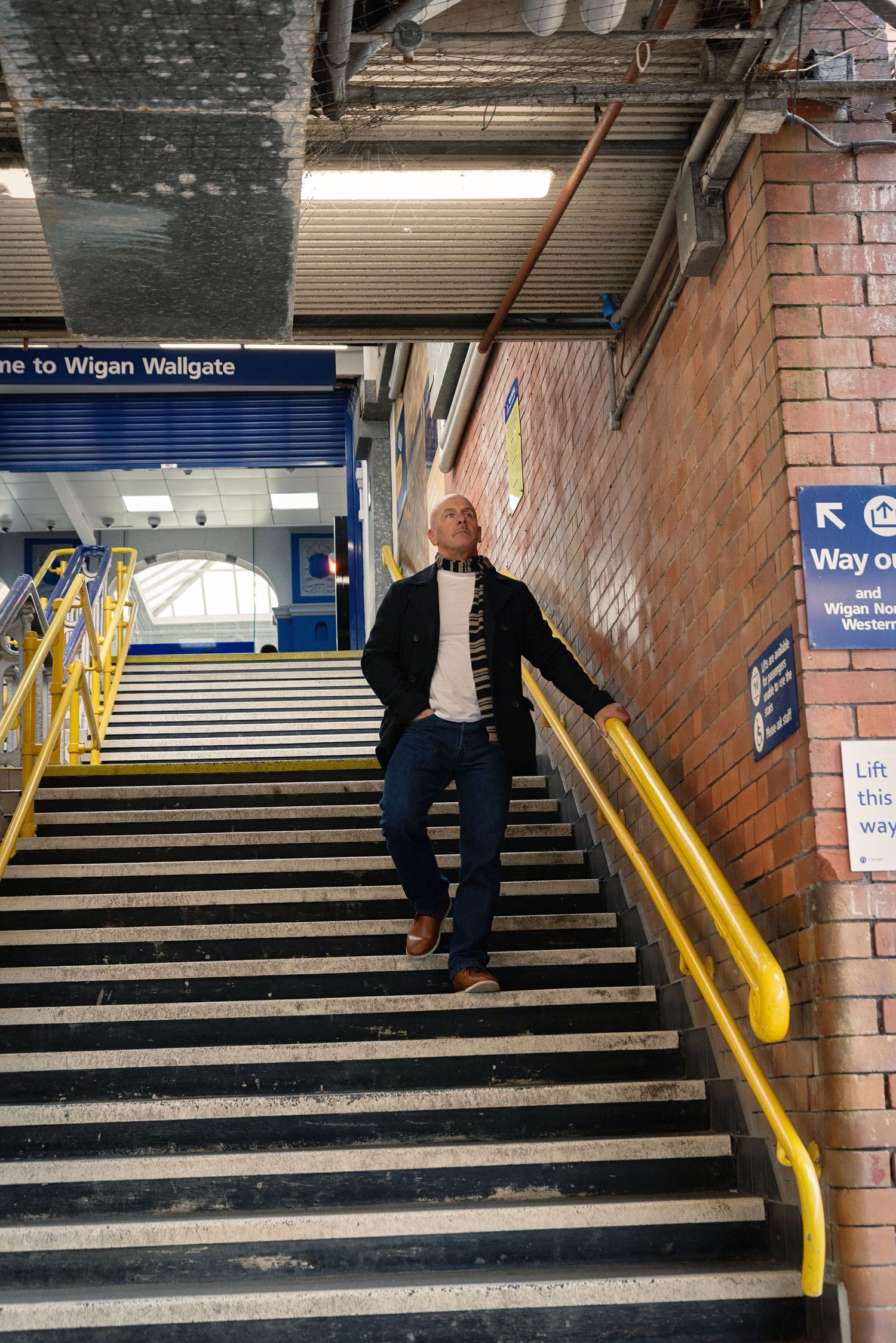A sequence of photos showing someone walking up a set of brick-walled stairs with yellow handrails in a train station.