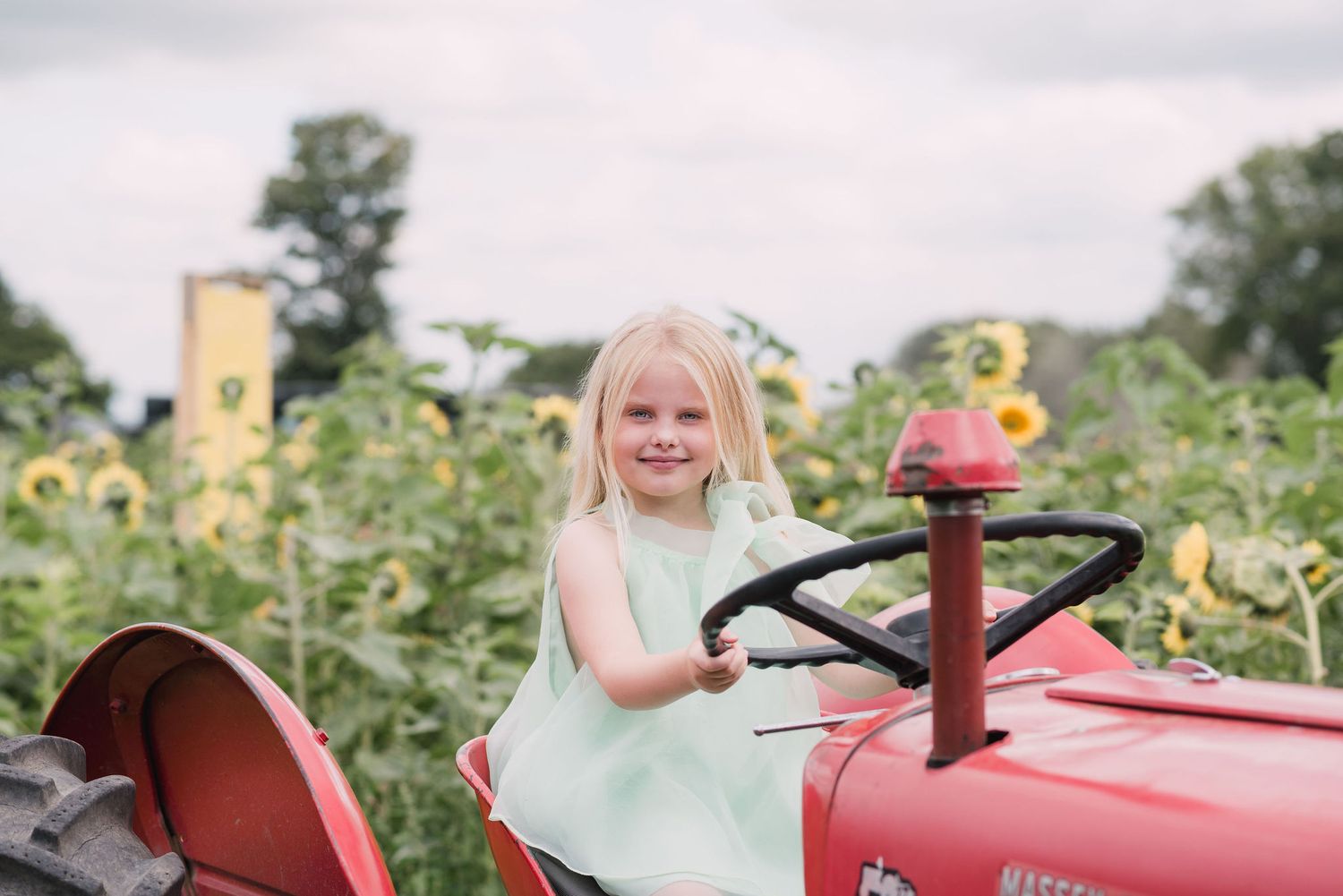 A collage shows a child playing on a vintage red tractor in an outdoor garden setting with flowers and greenery.