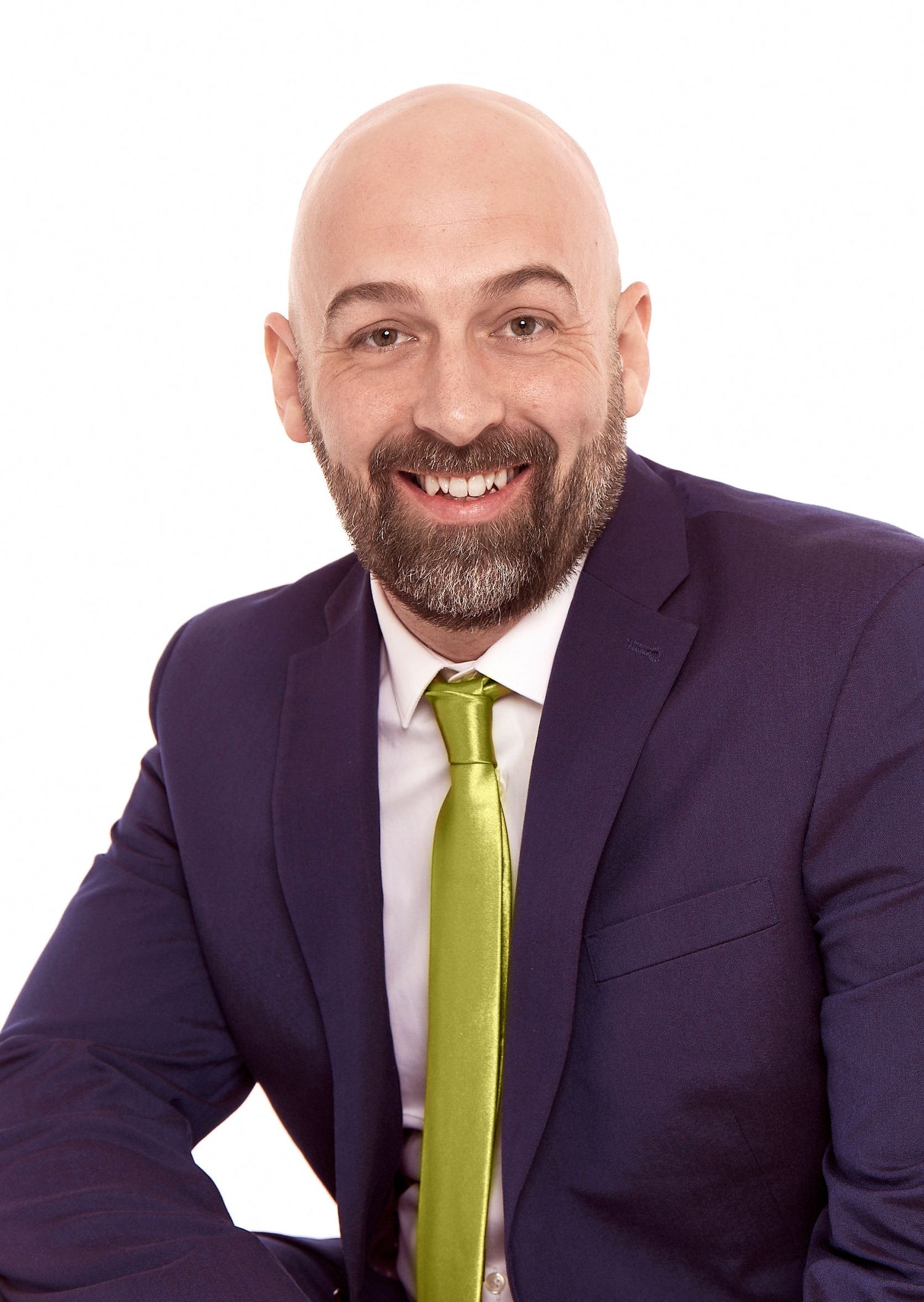 Professional in navy suit with lime green tie smiling against white background.
