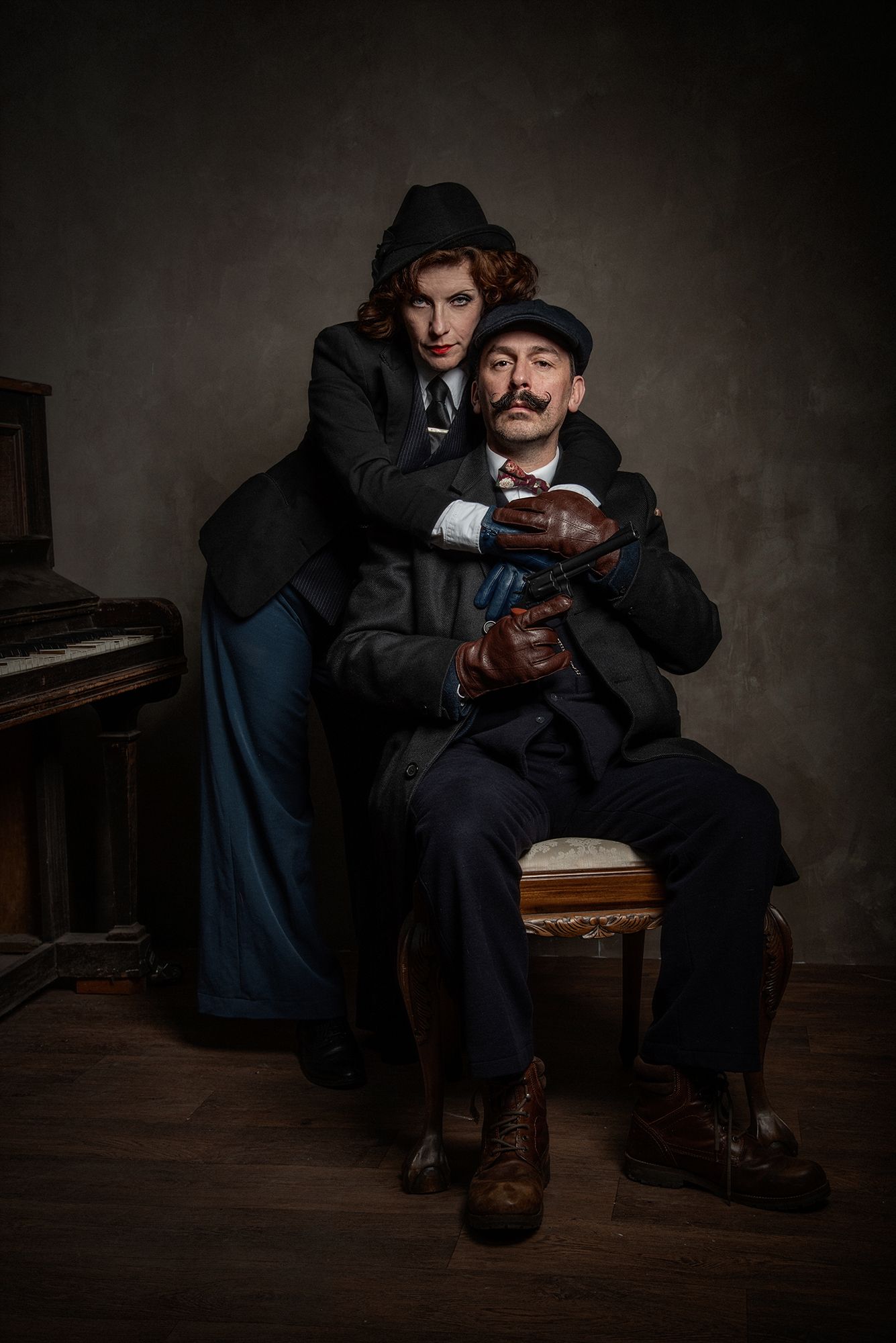 Dramatic vintage-style portrait of two figures in period costume near piano.