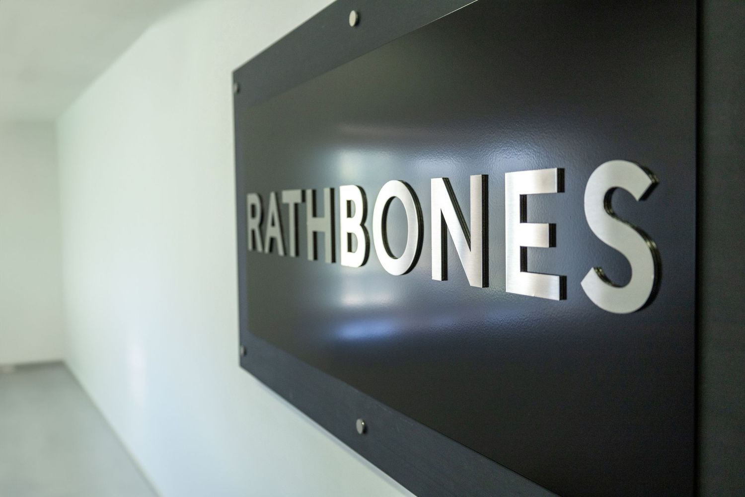 Illuminated Rathbones company sign mounted on interior wall.