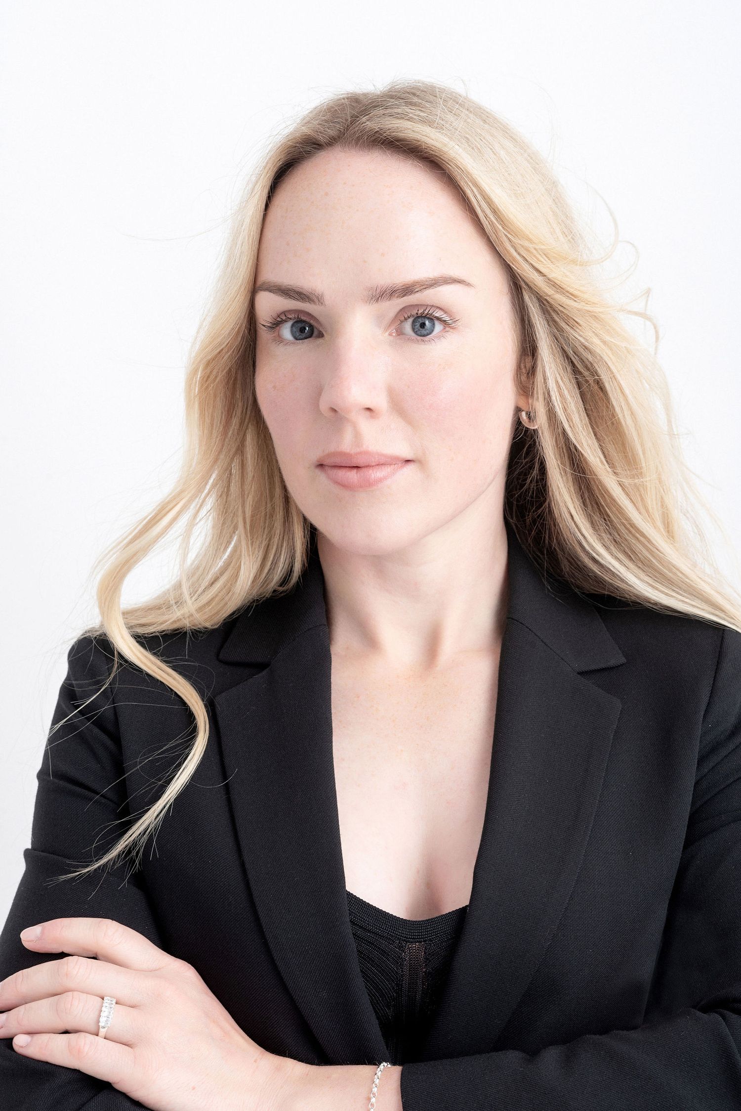 Professional headshot of a woman in a black blazer against a white background.