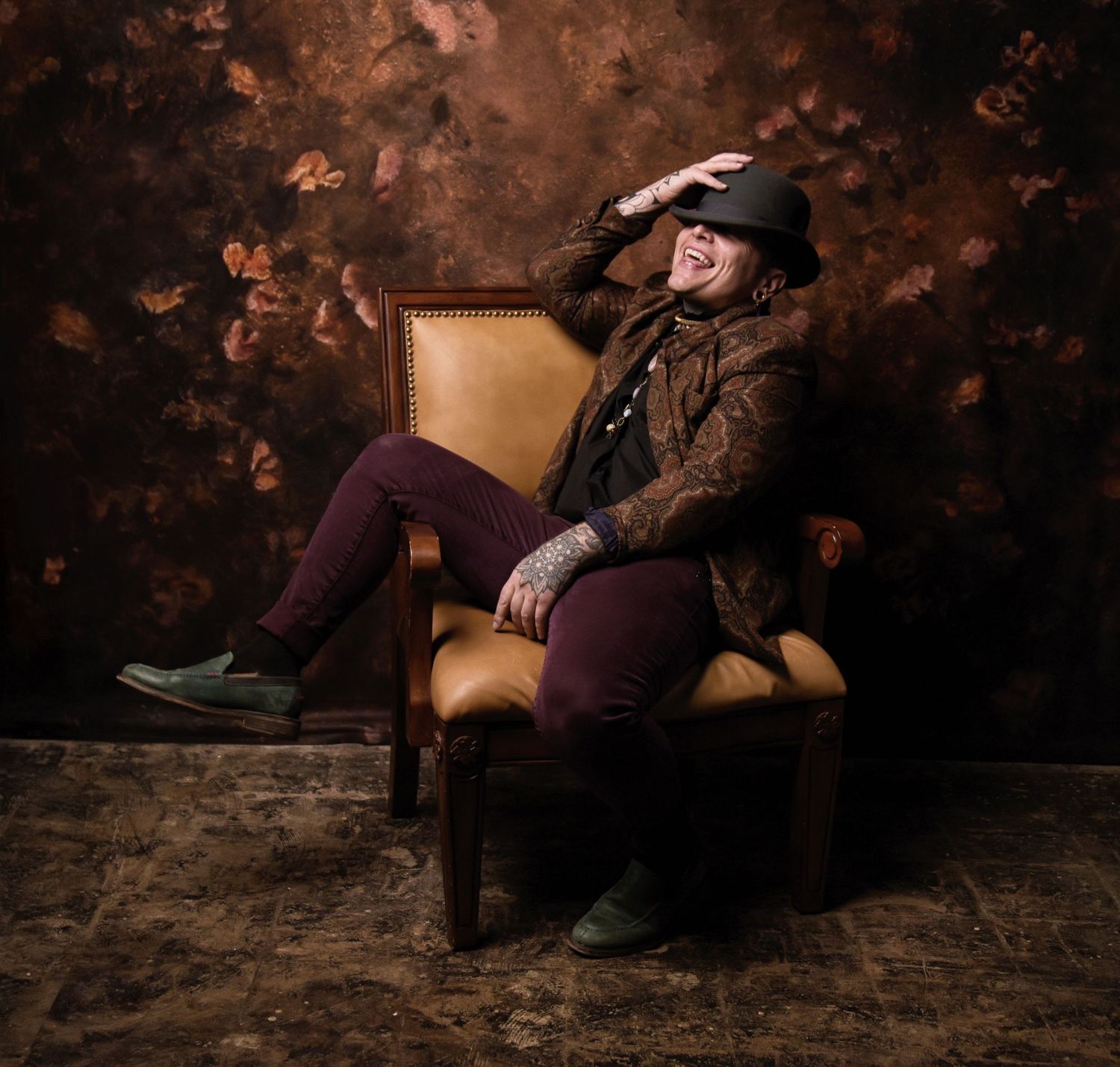 Person in vintage attire lounging dramatically in antique chair.