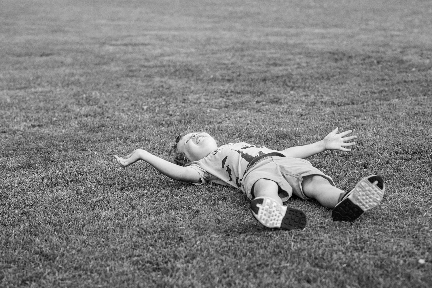 A person lies motionless on grass in a black and white photo sequence showing different resting positions.