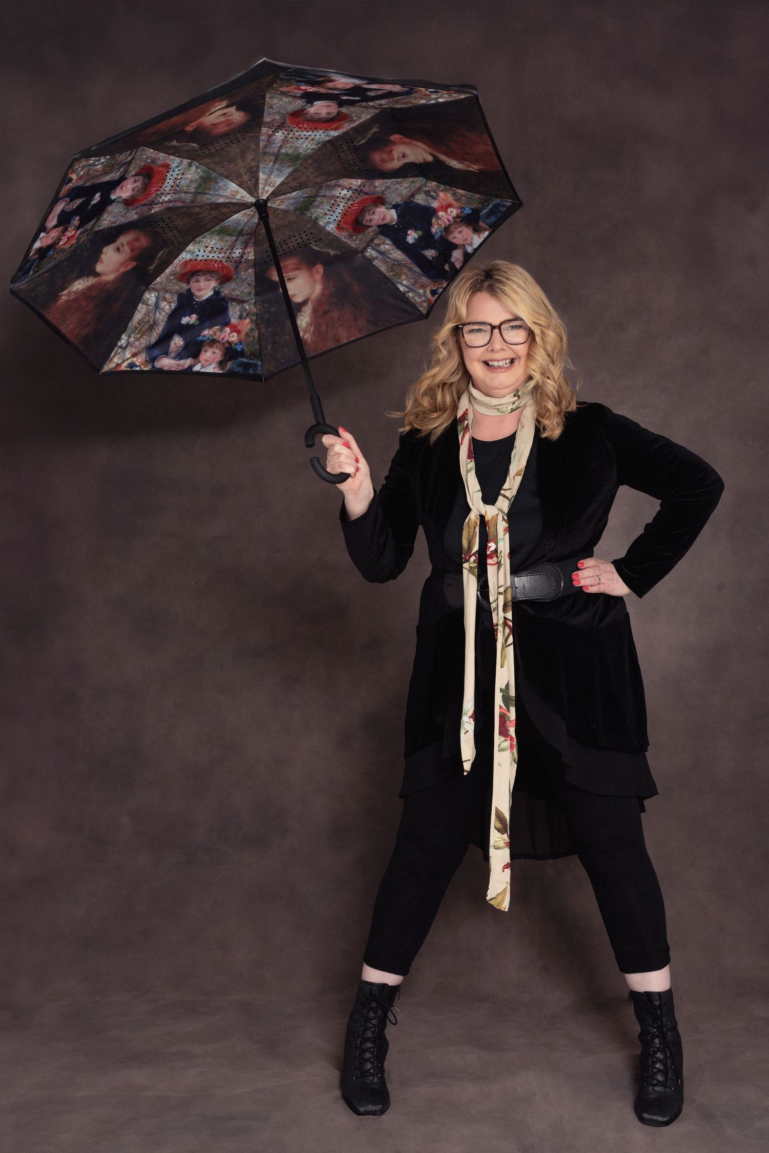 Playful studio portrait with decorative umbrella, black velvet jacket and boots.