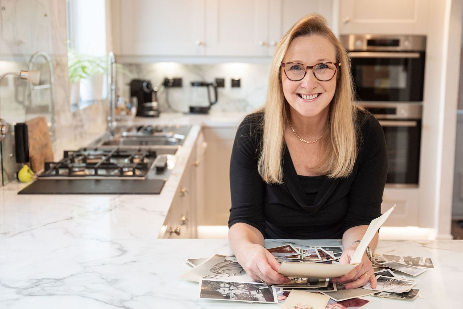 Casual kitchen scene with cookbook viewing on marble countertop.