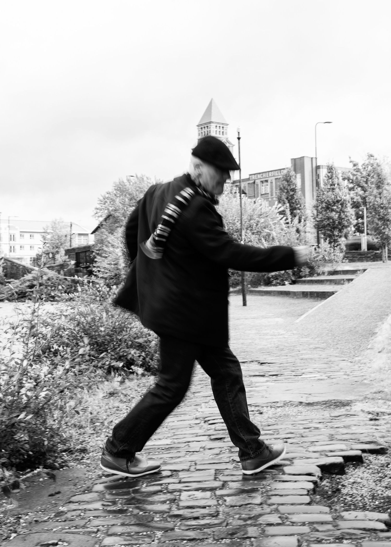 A sequence of black and white photos showing a person slipping and falling on a wet cobblestone path.