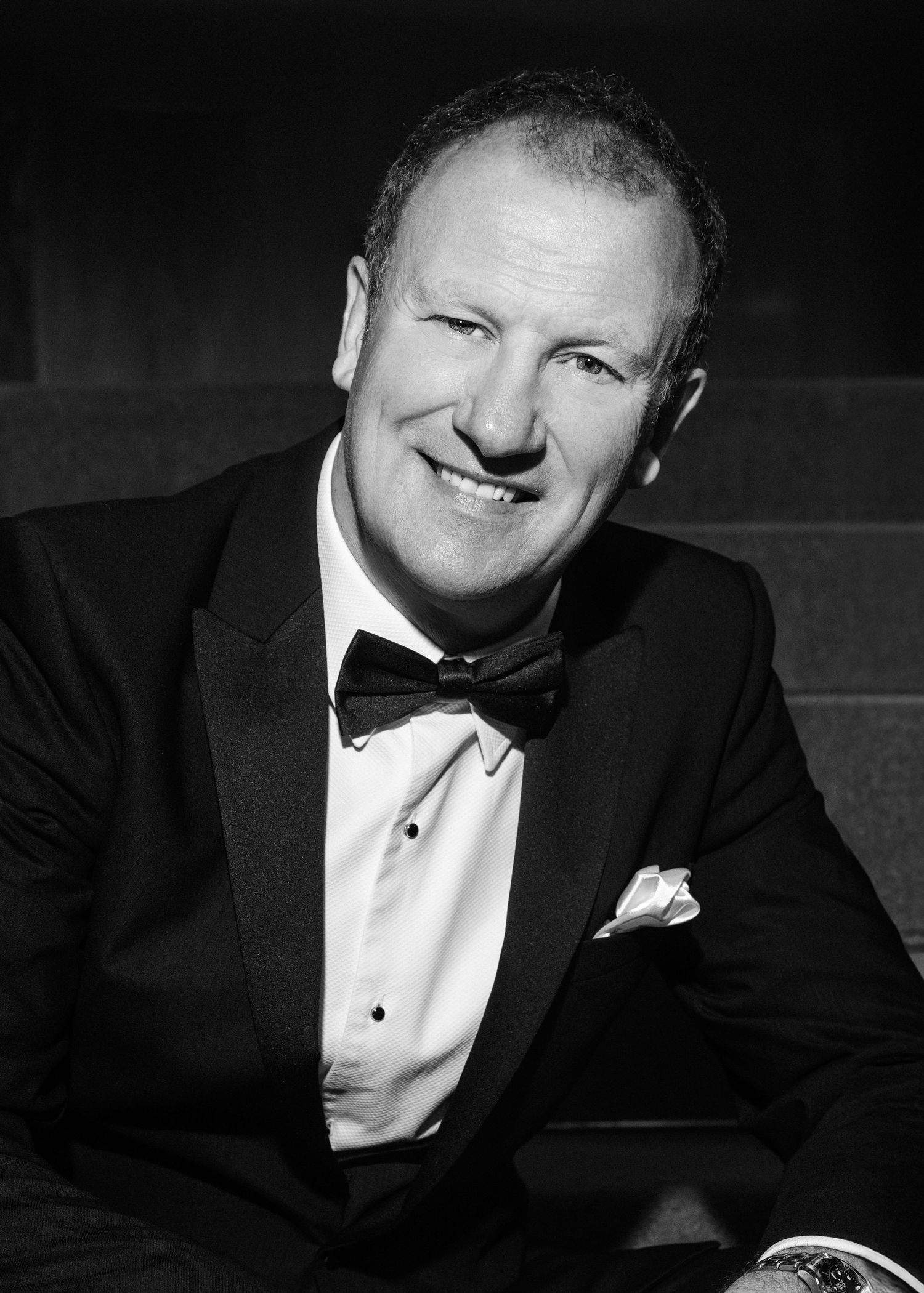 Classic black and white headshot of a gentleman in formal tuxedo and bowtie.