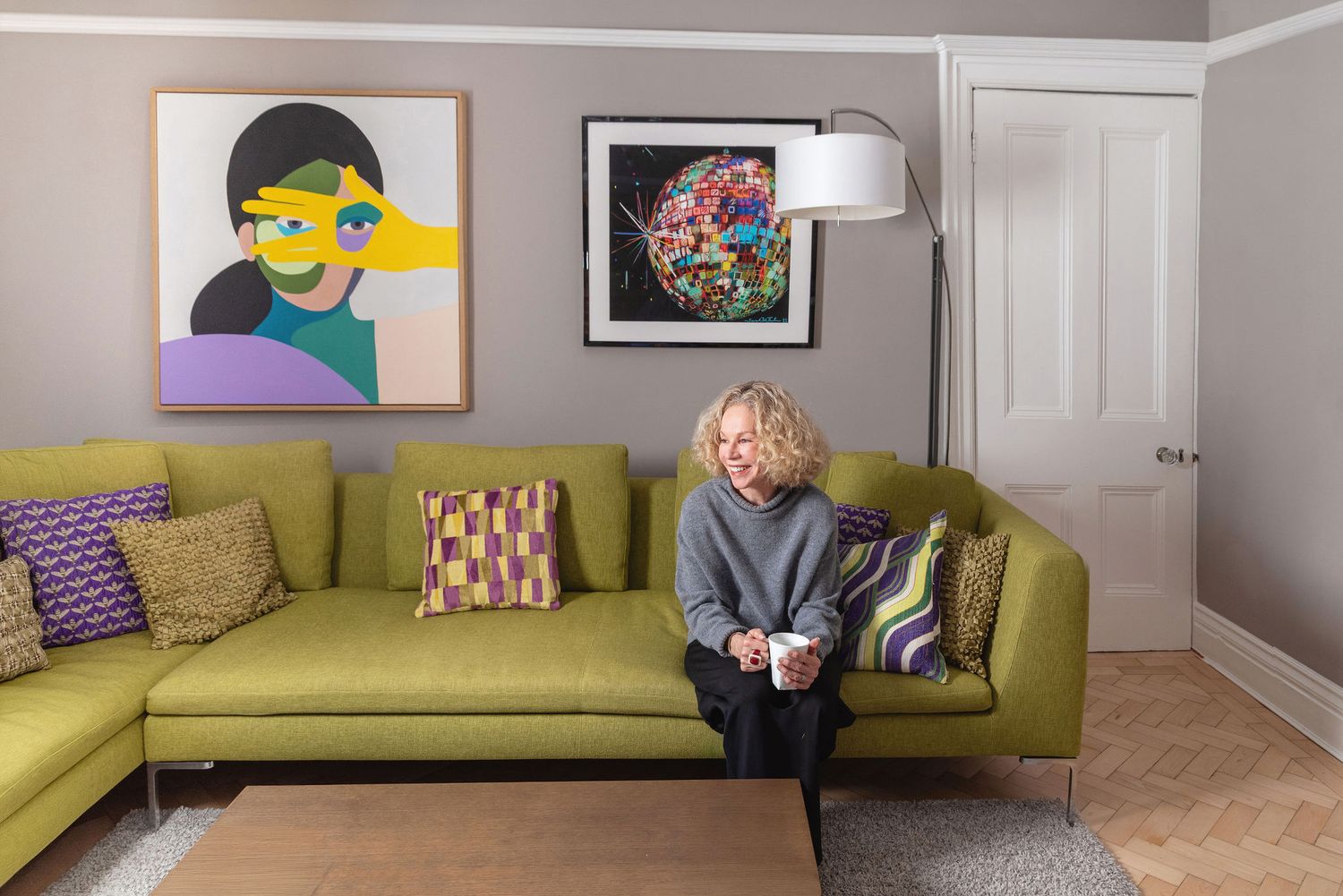 Modern living room features a chartreuse green sofa against white walls with contemporary artwork and decor.