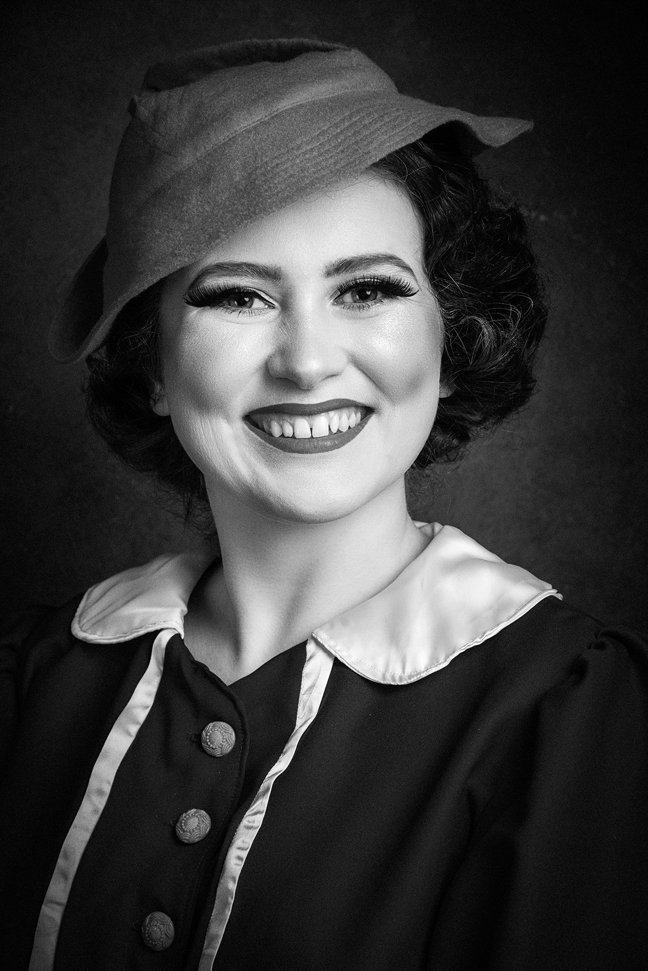Black and white vintage-style portrait showing 1940s hat and collar fashion styling.