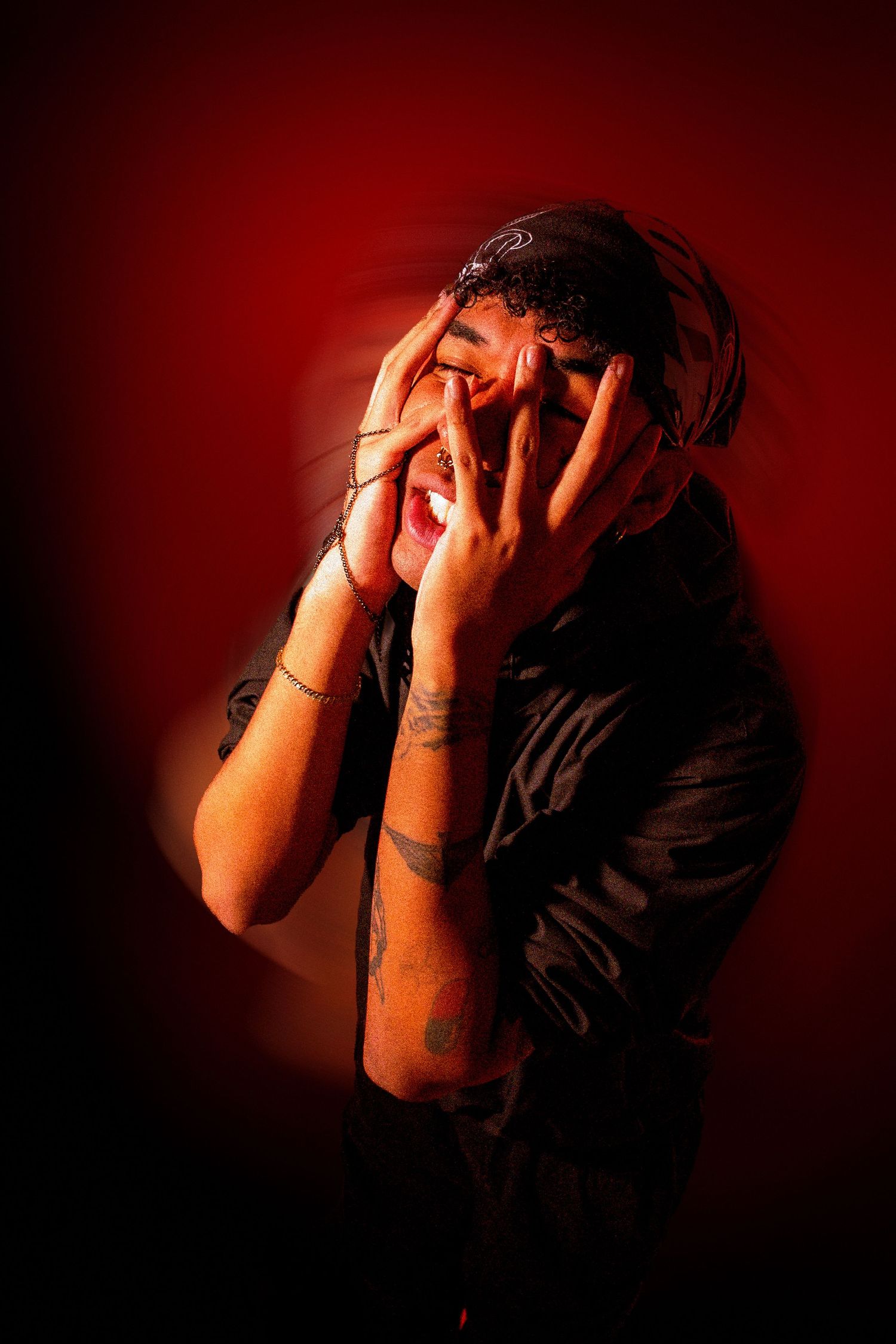 Dramatic portrait series showing person in dark shadows covering their face against deep red background.