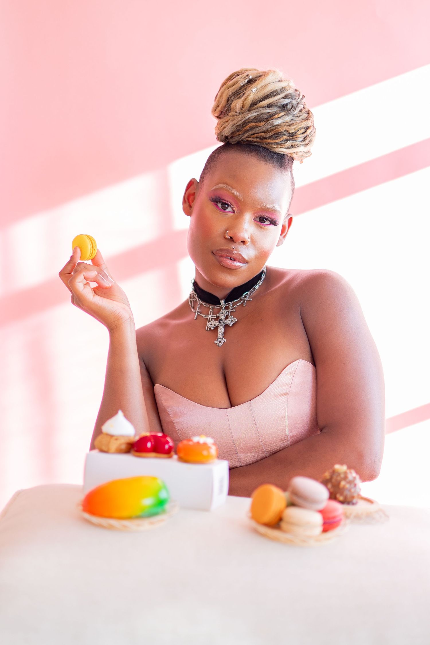 A series of pink-tinted photos showing someone posing with colorful fruit against a soft, dreamy background.
