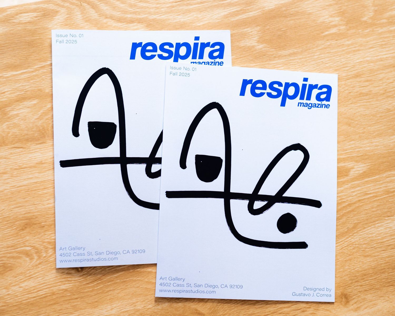 Two minimalist design prints with 'respira' text and abstract line art on wooden surface.