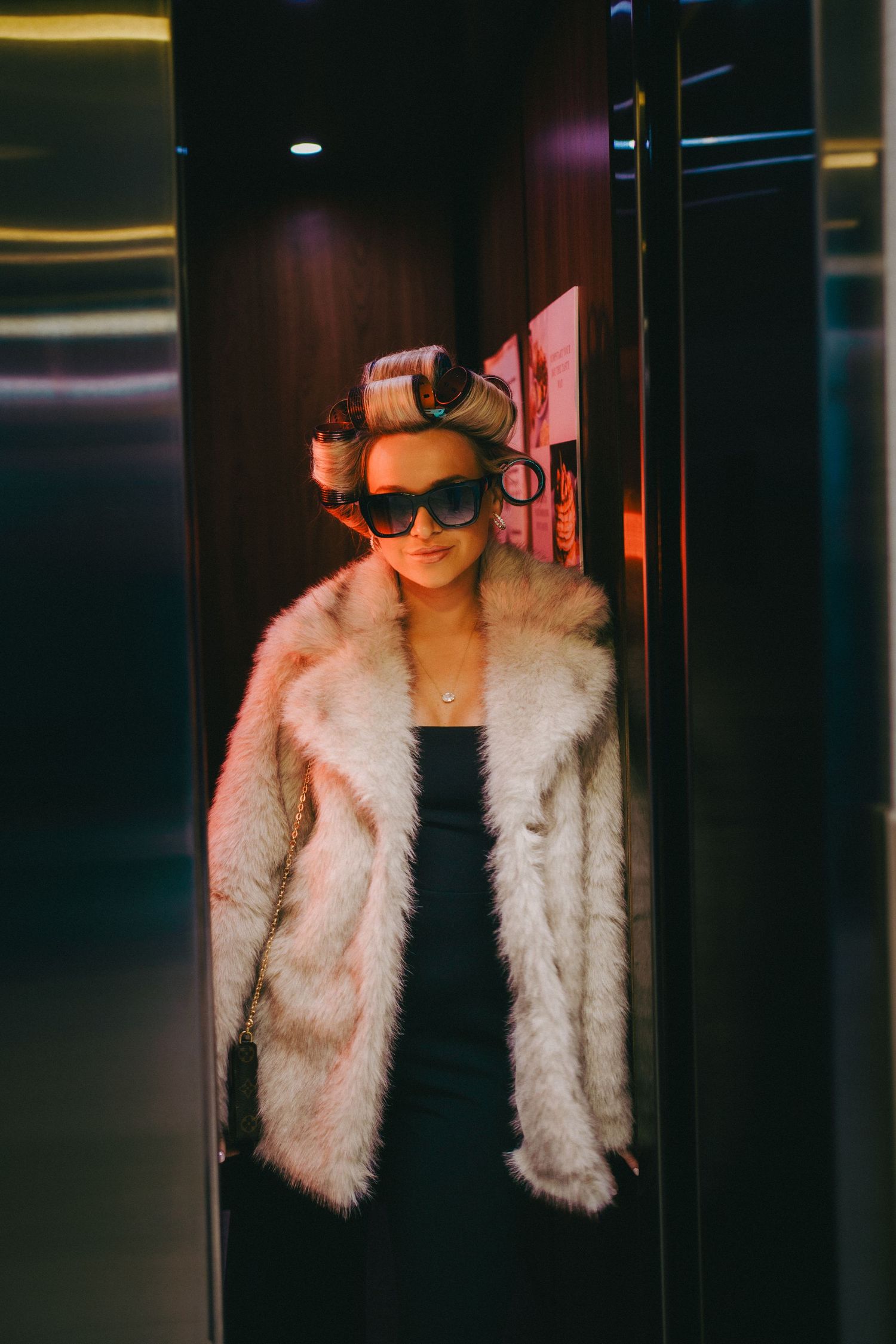 Girl with rollers in her hair and sunglasses on smiles as elevator door closes at the Cambria Hotel in Ocean City, Maryland.