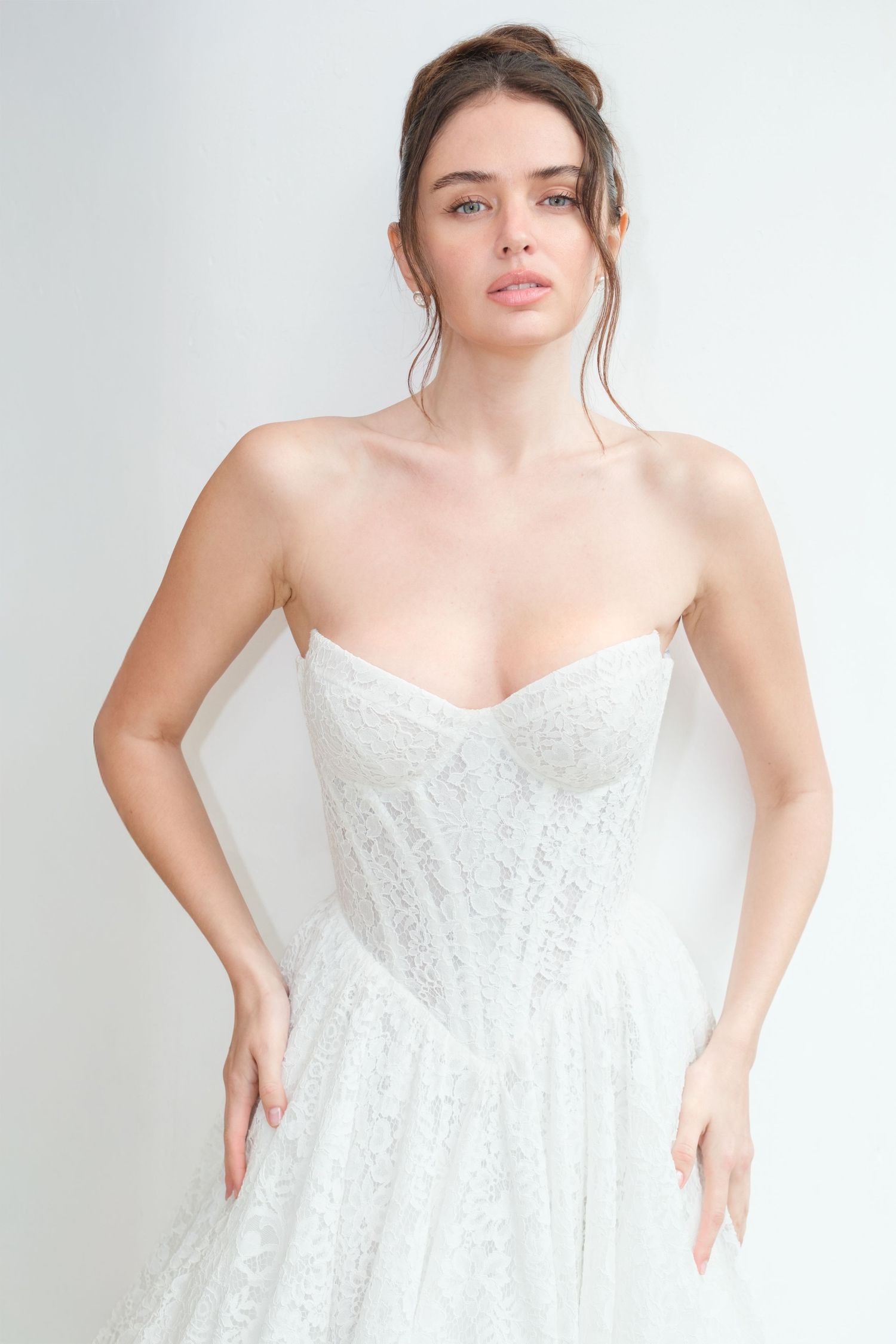 Strapless ivory lace wedding gown with a sweetheart corset bodice and full A-line skirt, styled with an elegant updo.