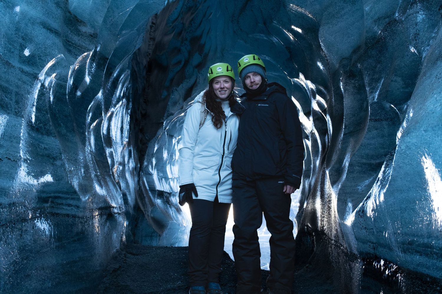A dramatic scene shows a person in a dark icy cave with blue lighting and reflective surfaces.