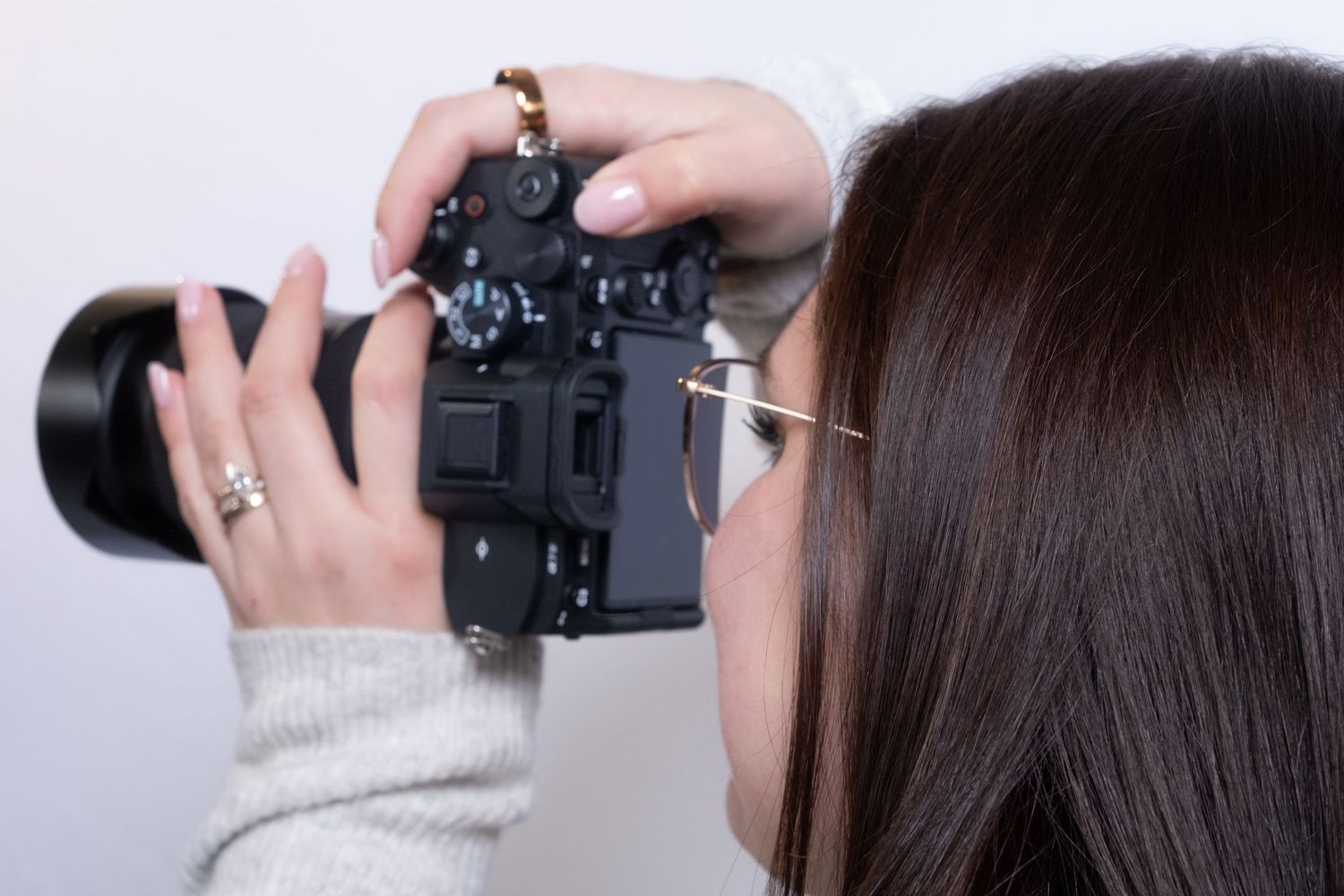Close-up shots demonstrating how to properly hold and operate a DSLR camera from multiple angles.