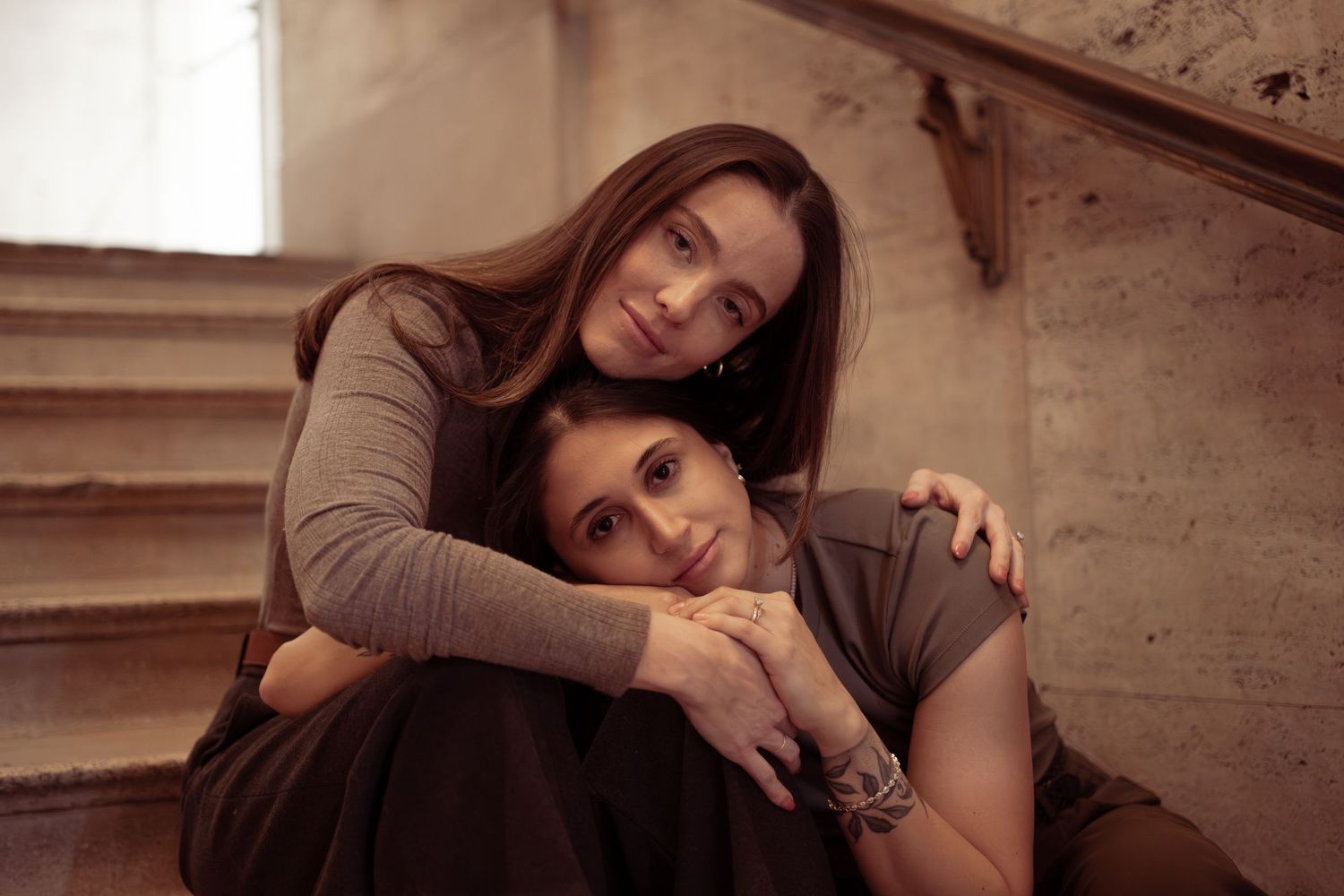 A series of sepia-toned photographs showing tender moments between two people on wooden stairs.